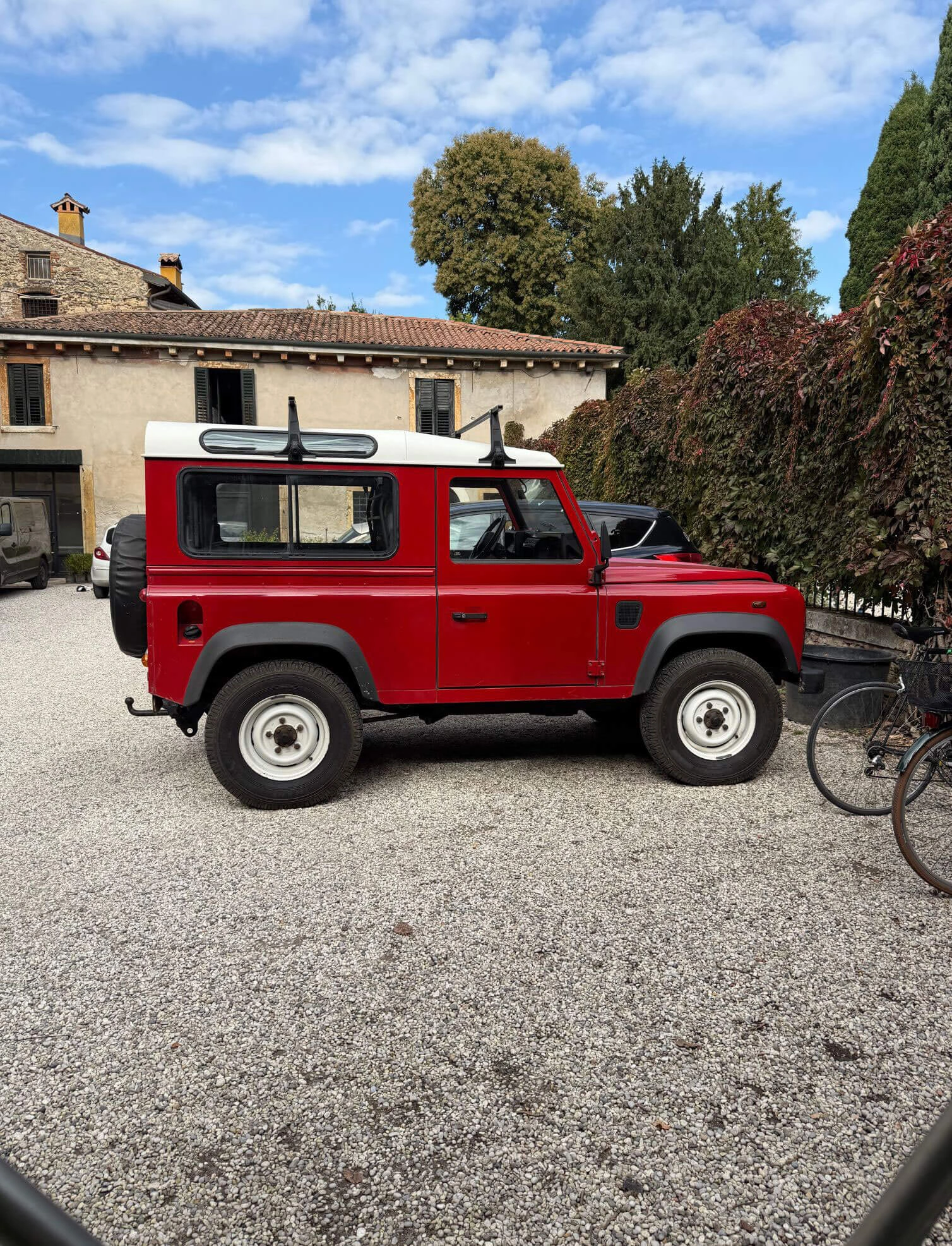 Red off-road vehicle in a gravel courtyard