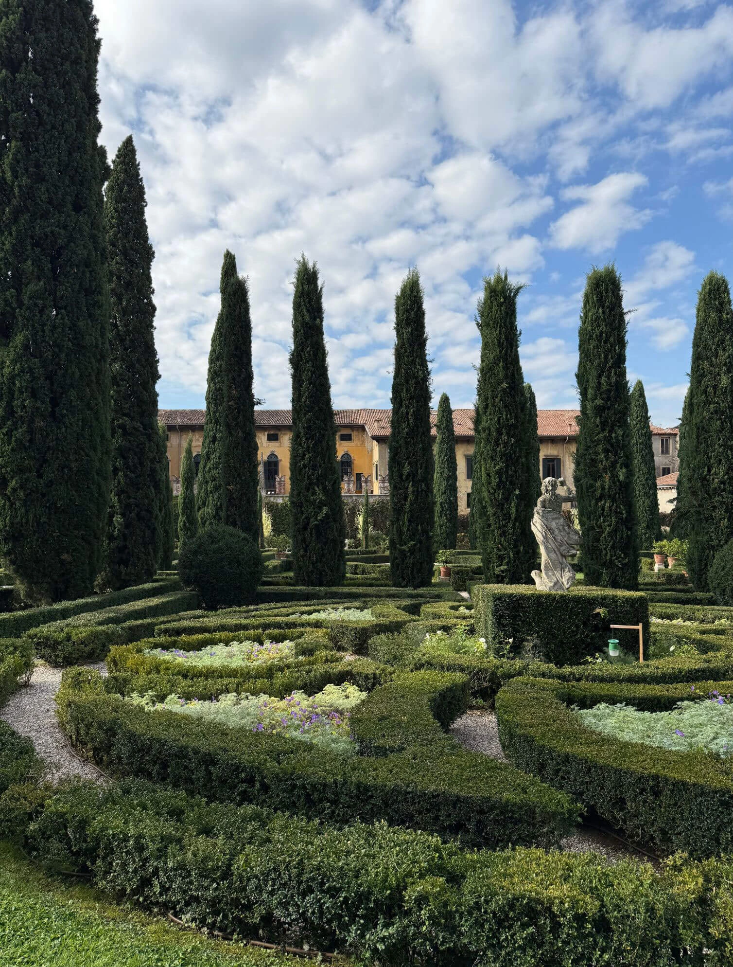 Formal garden parterres beneath an avenue of cypresses