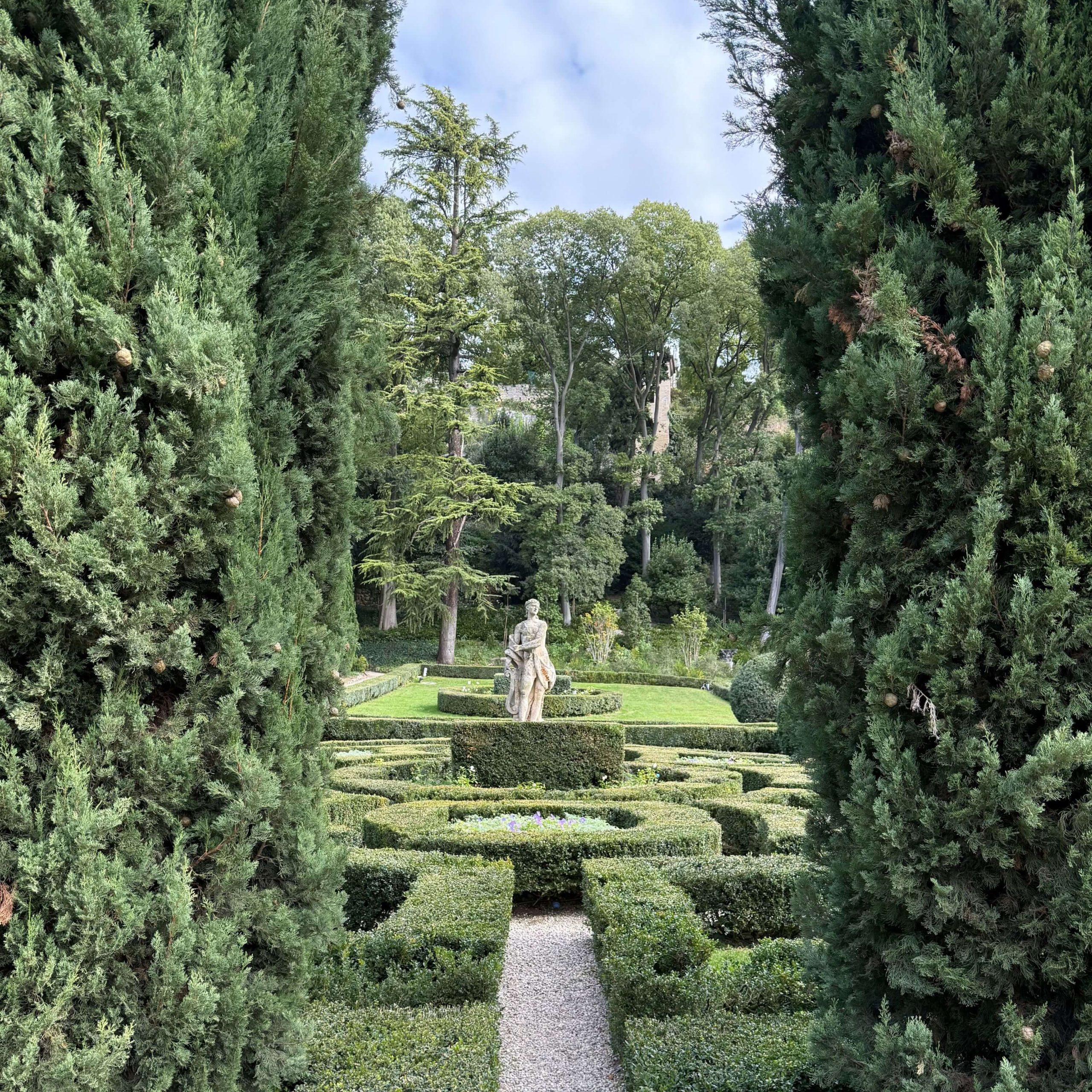 Garden statue framed by dense cypress planting