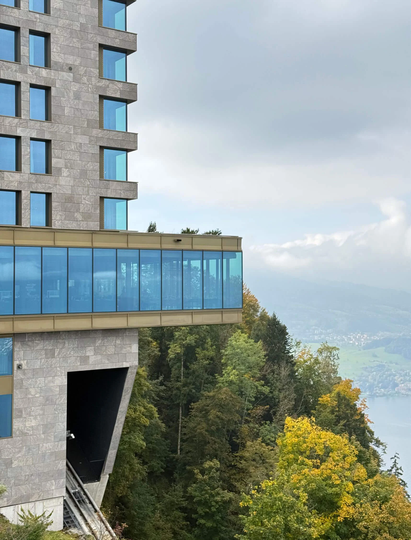 Glazed hotel wing extending above the hillside