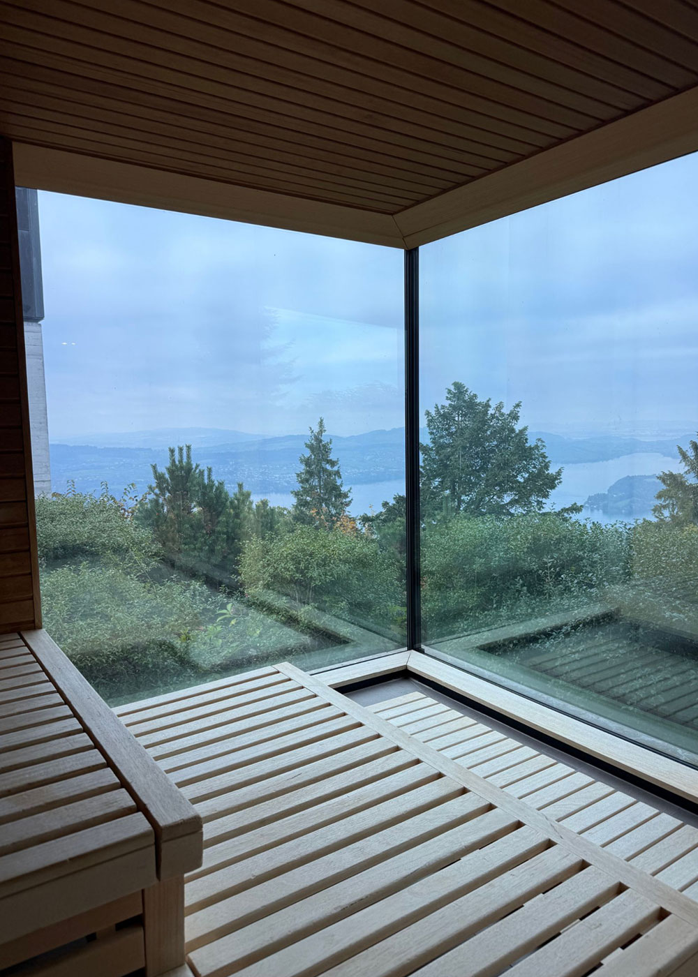 Recliners beside corner windows overlooking trees and sky