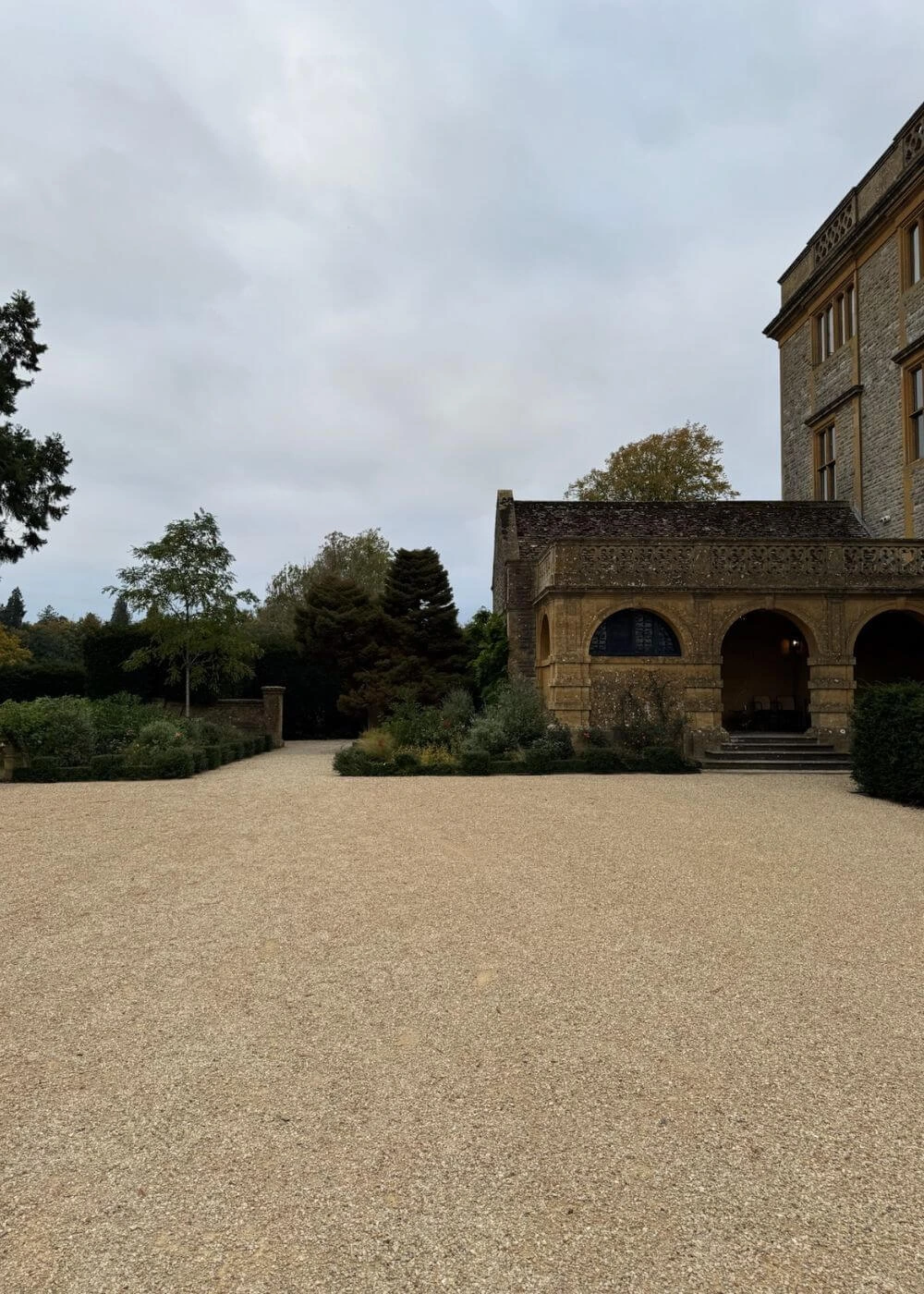 Gravel courtyard beside an arched stone loggia