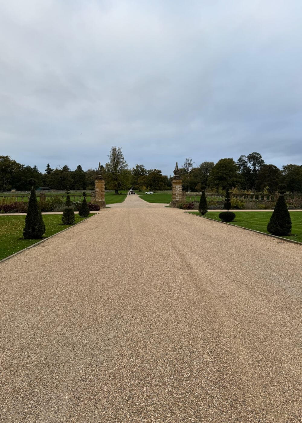 Long straight gravel walk between formal garden beds