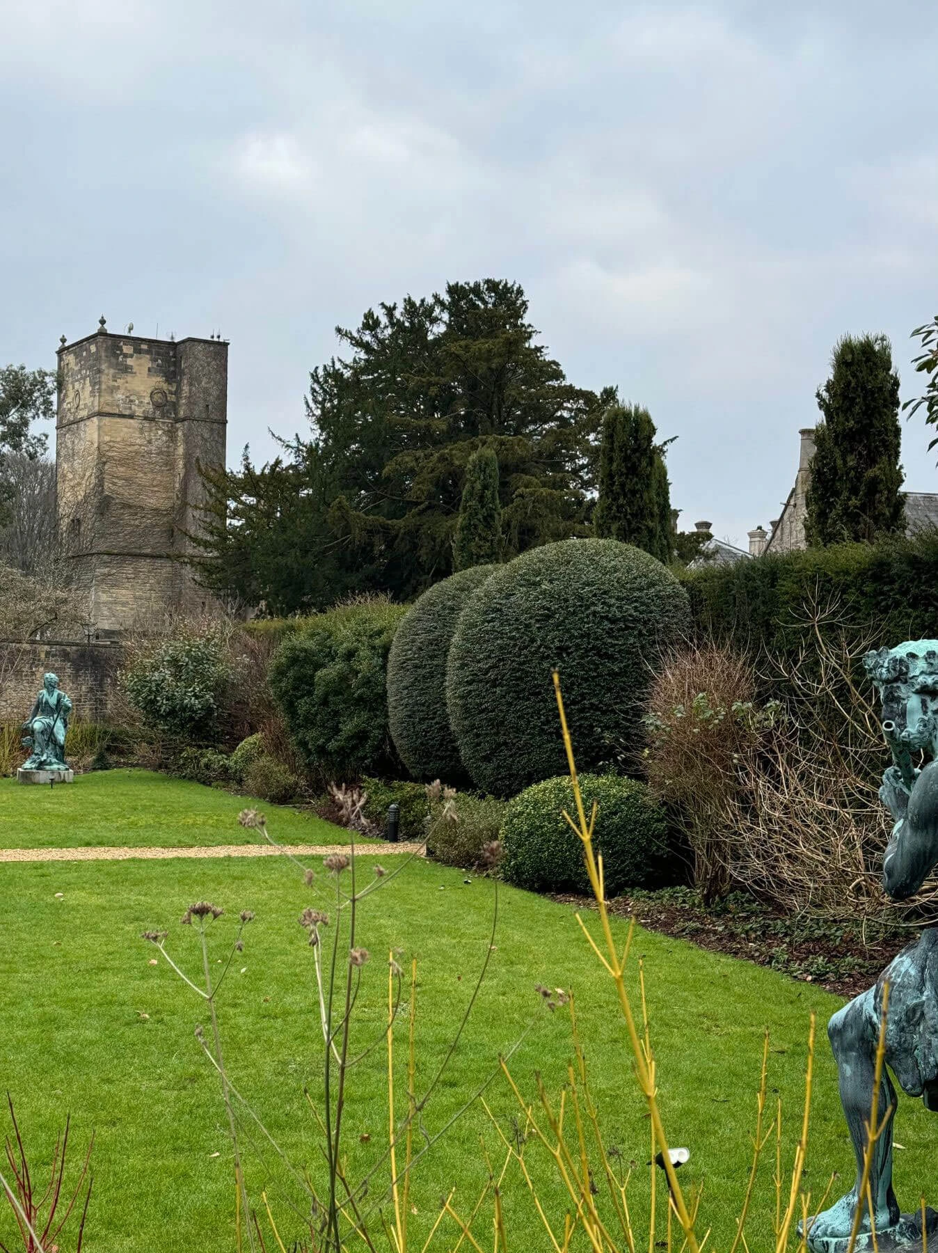 Sculptures and rounded hedges on a garden lawn