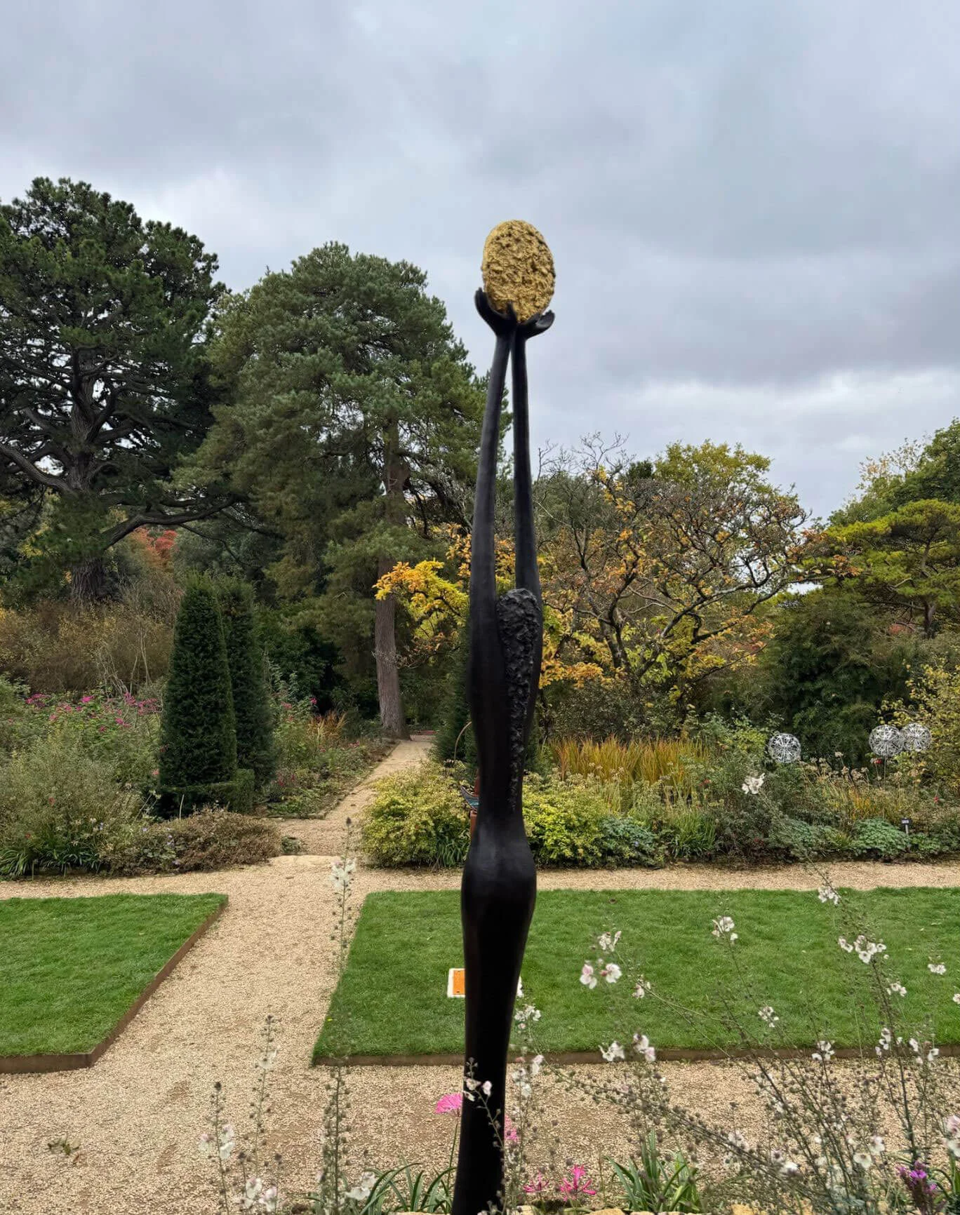 Tall narrow sculpture topped by a textured oval form