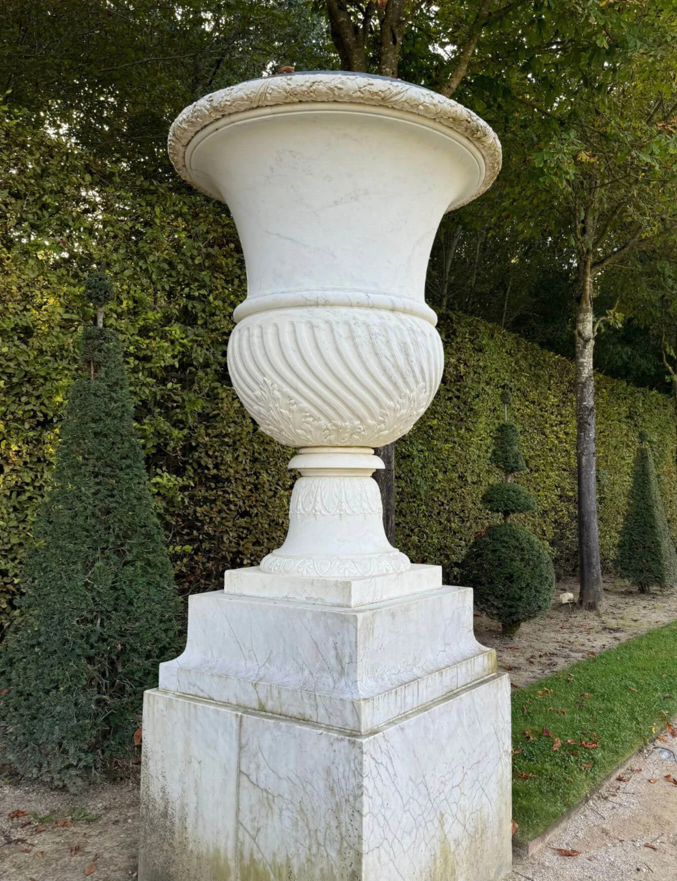 Ornamental stone urn on a square garden pedestal