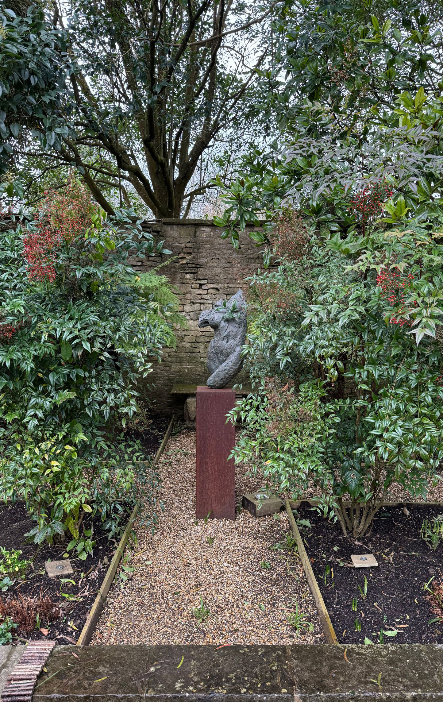 Weathered abstract figure beside a wooded path