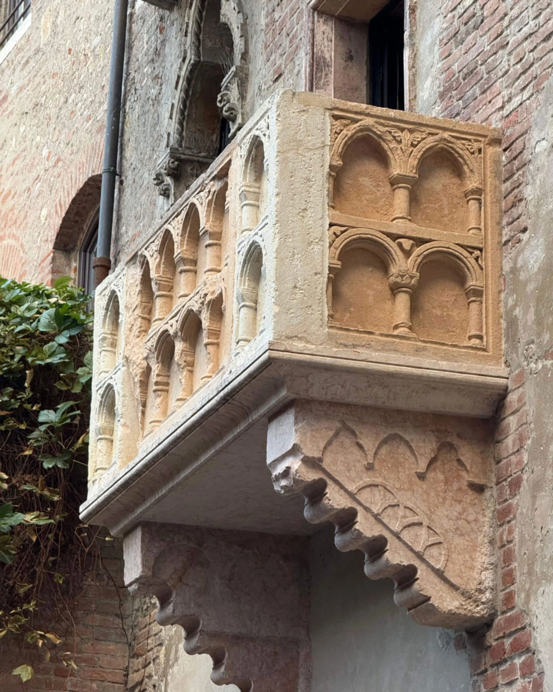 Carved Gothic stone balcony projecting from a brick facade