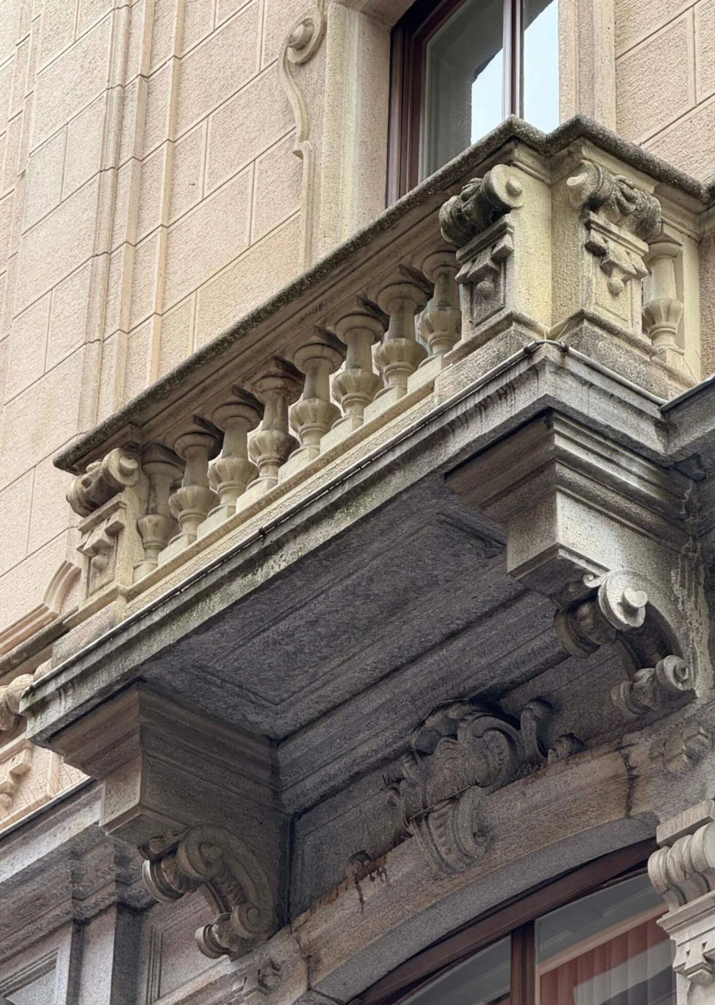 Sculpted stone brackets beneath an ornate balcony