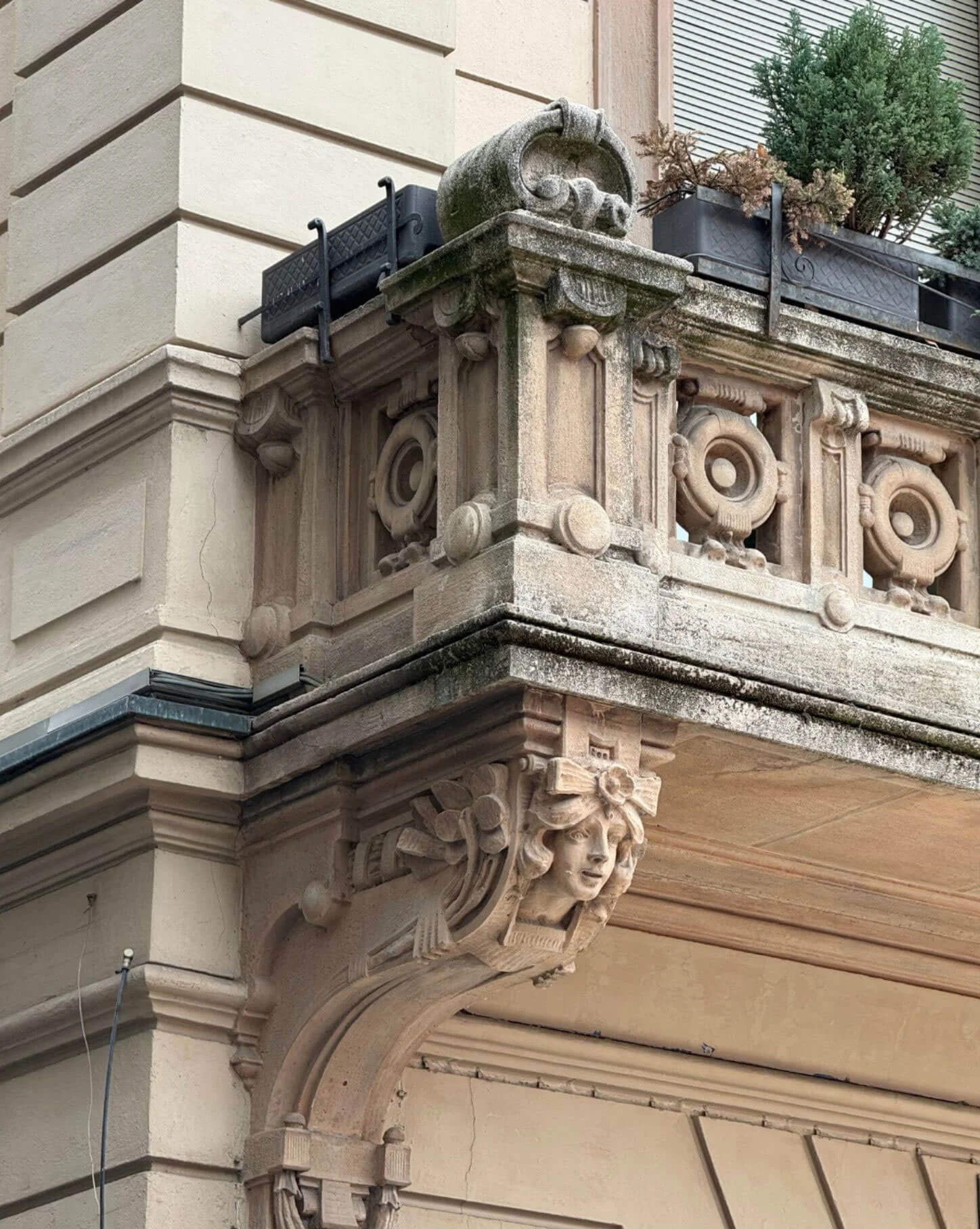 Balcony with scroll brackets and a patterned stone railing