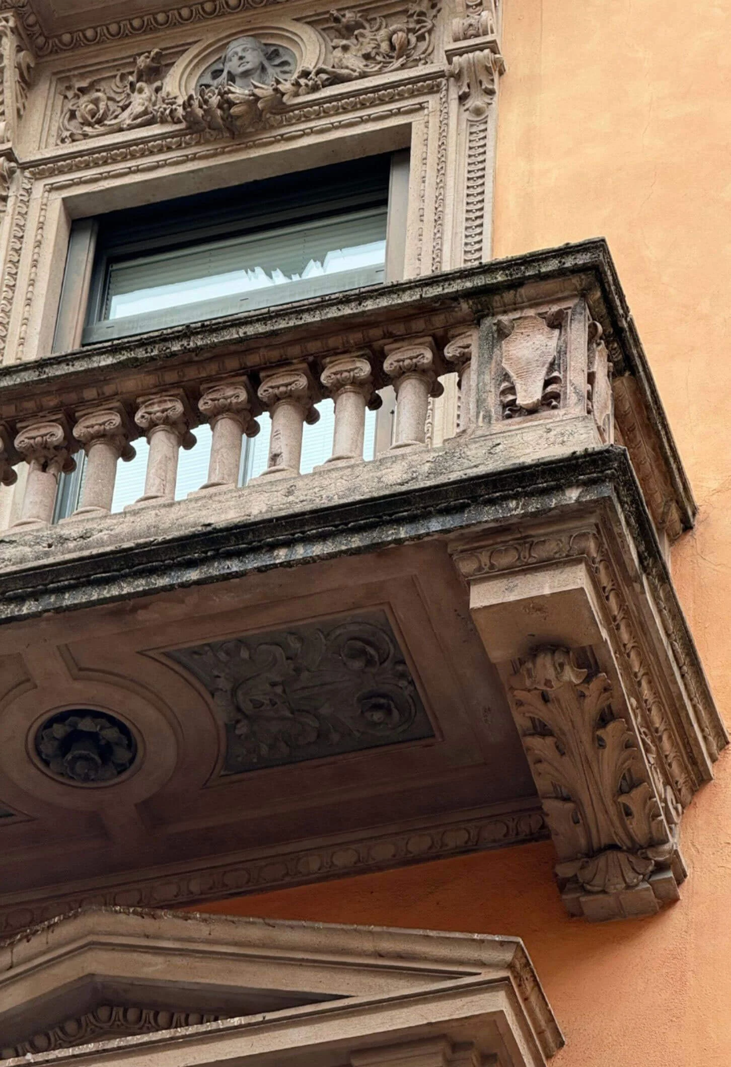 Stone balustrade above deep carved balcony brackets