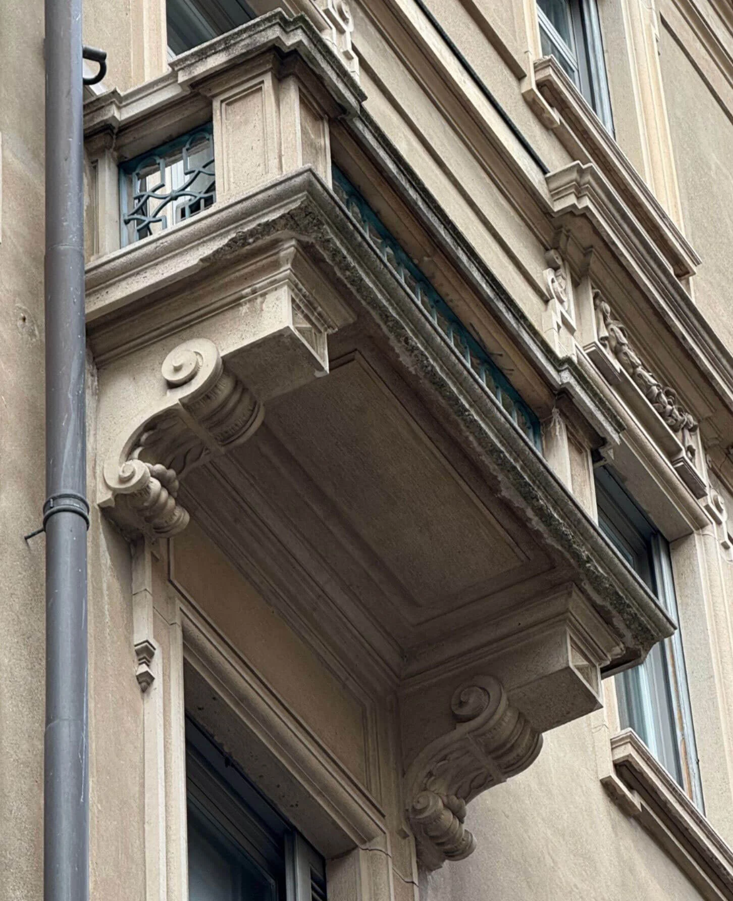 Balcony underside framed by scroll-shaped supports