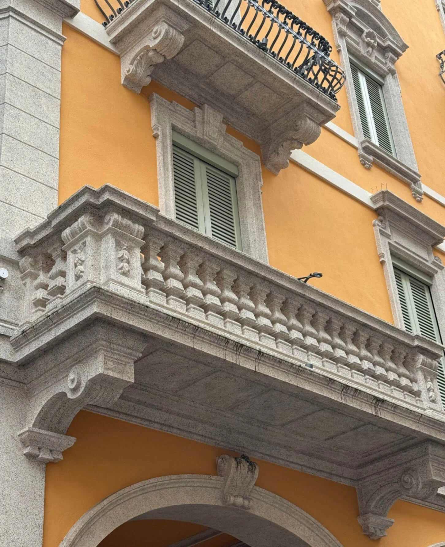 Stacked stone balconies against an ochre facade