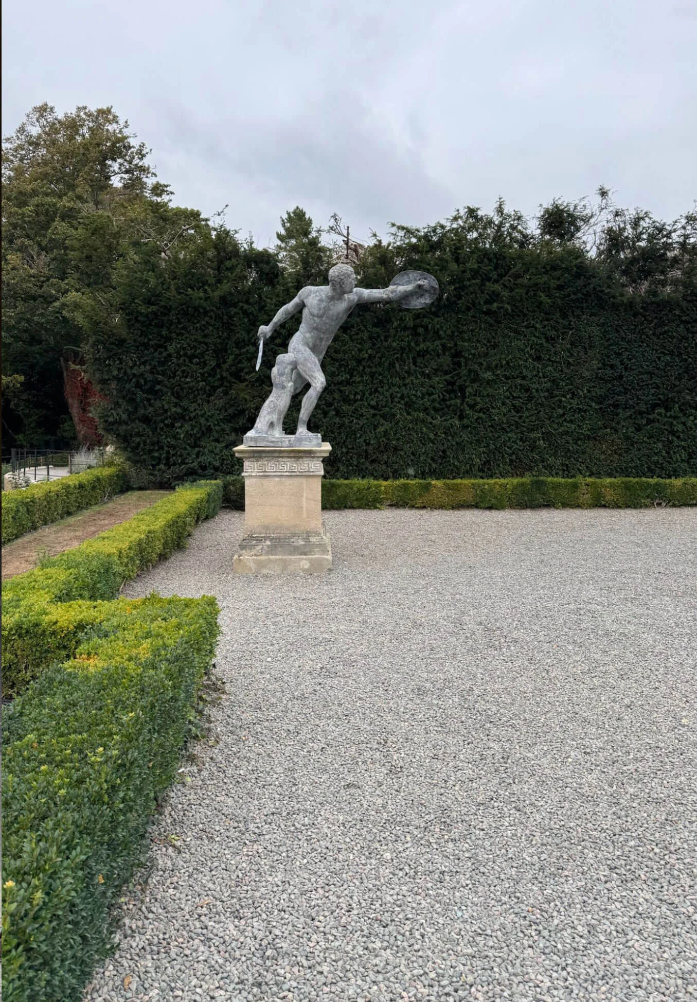 Classical garden statue beside a gravel path