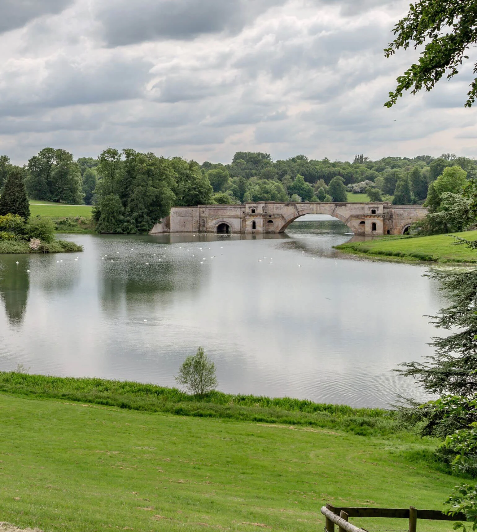 Stone bridge spanning a landscaped lake
