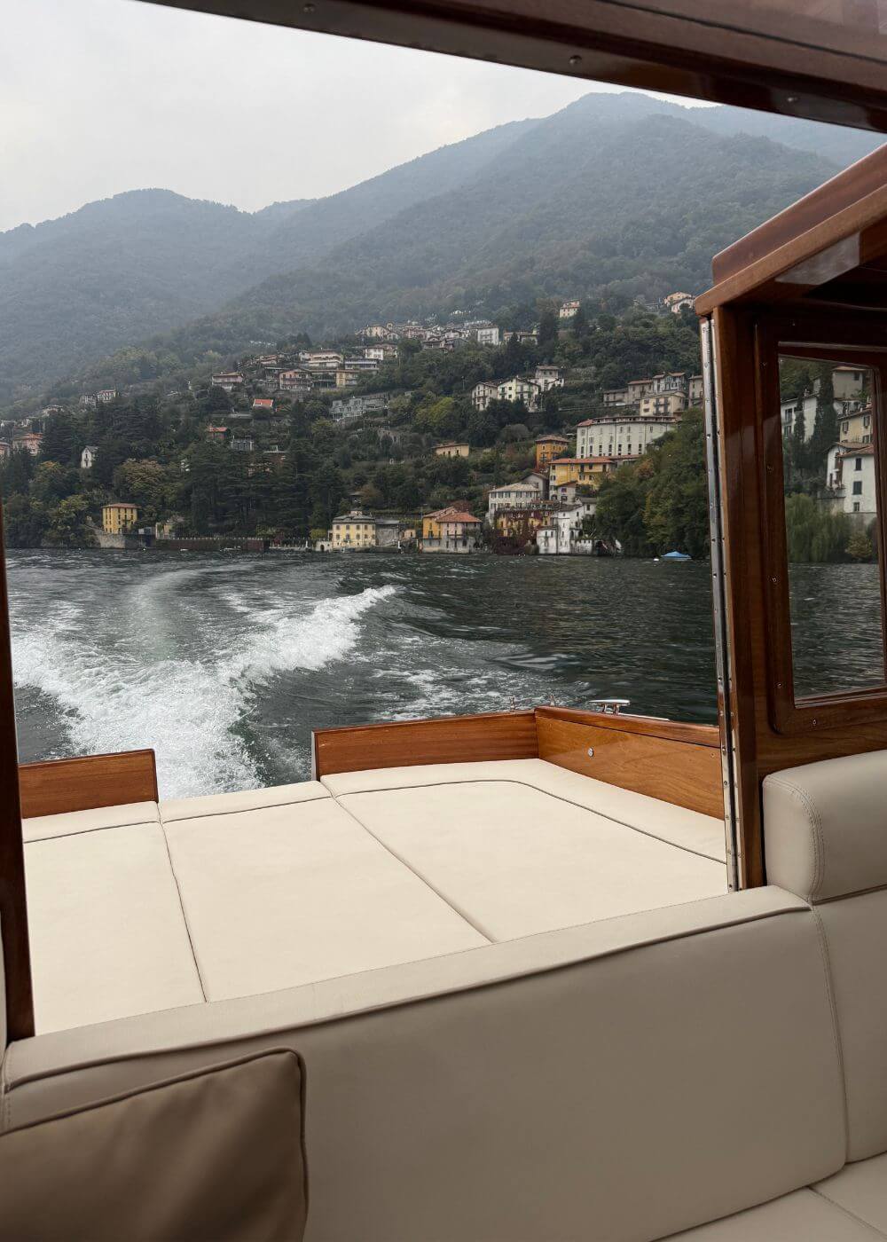 Mountain shoreline viewed through a wooden boat cabin