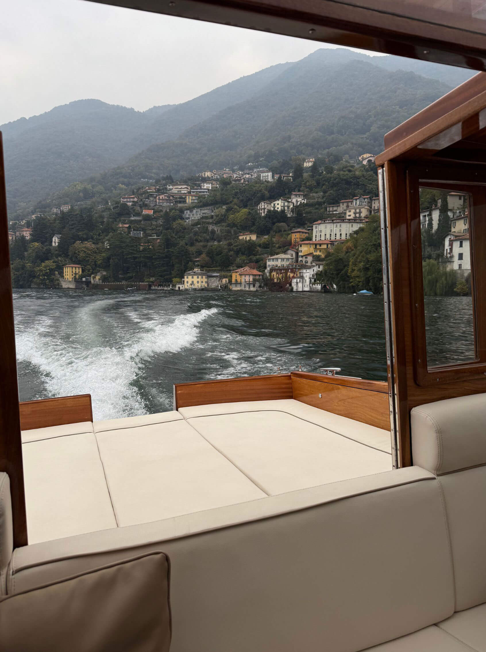 Lake and mountains seen from a boat’s covered seating area