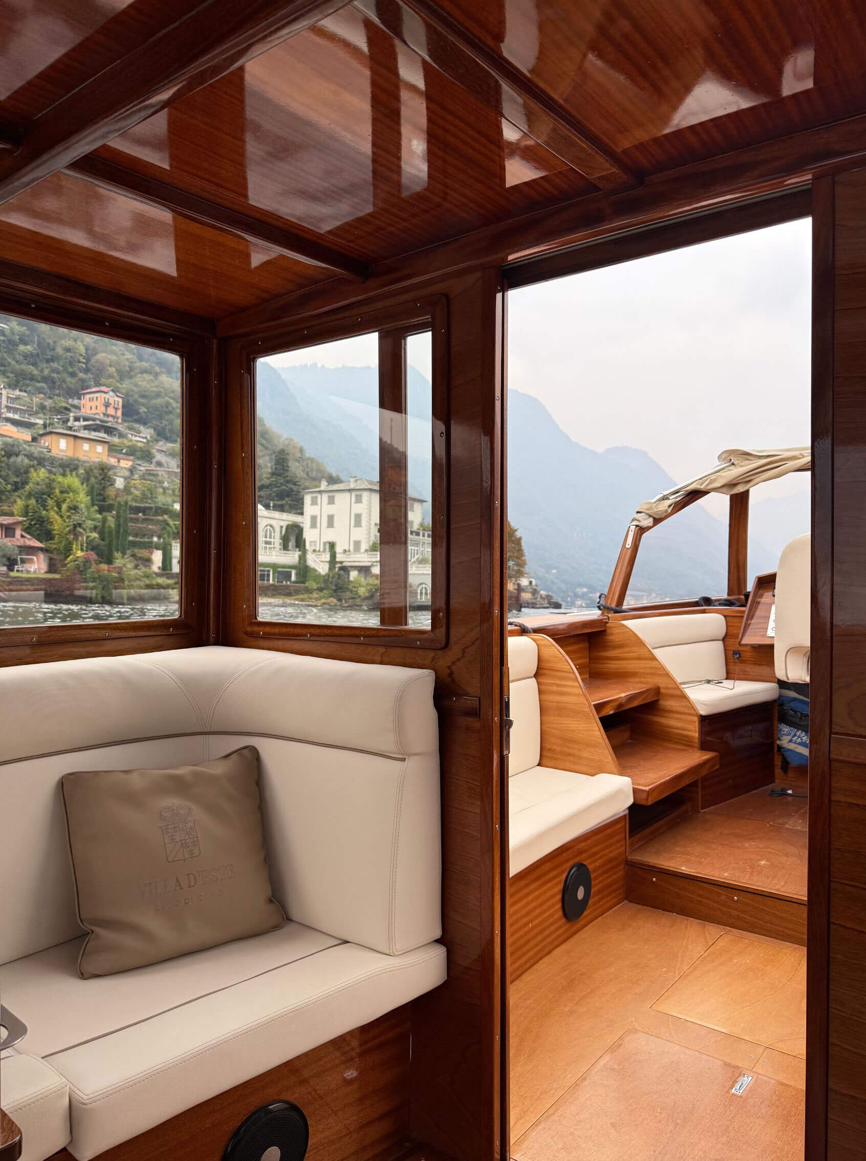Wood-panelled boat cabin with cream upholstered seats