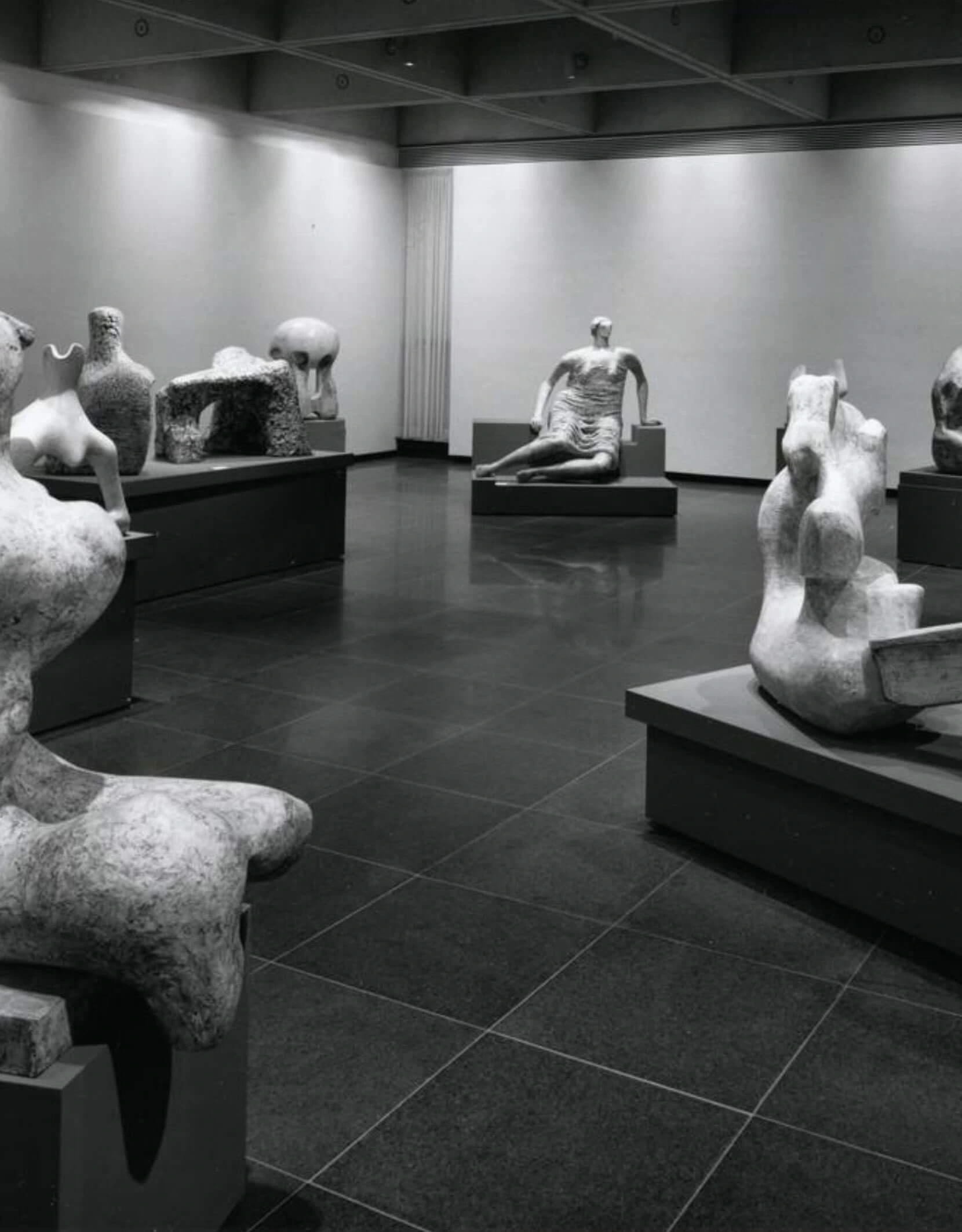 Sculptures arranged on plinths inside a gallery