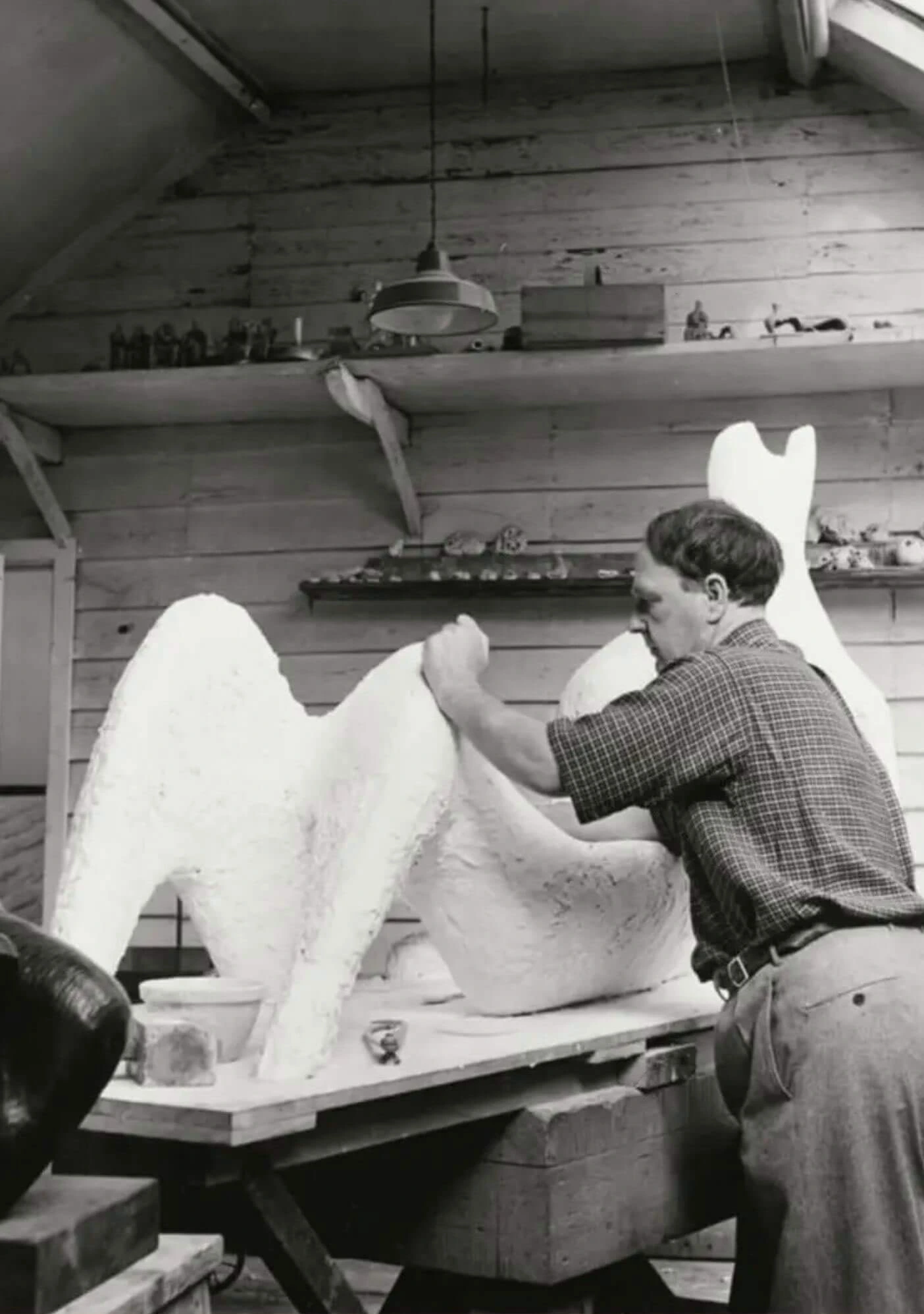 Sculptor working on a large pale model in a studio