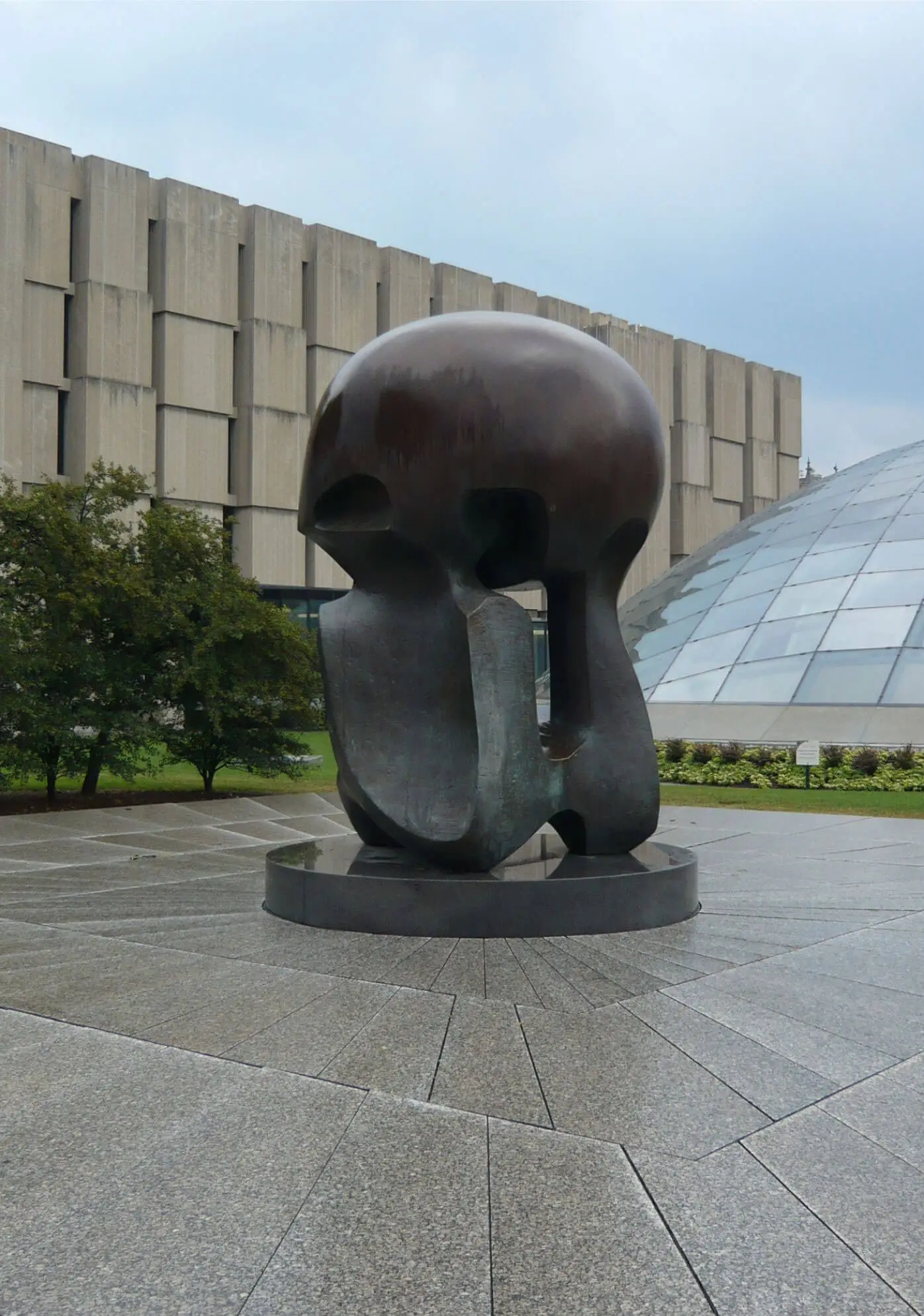 Rounded bronze sculpture outside a modern gallery