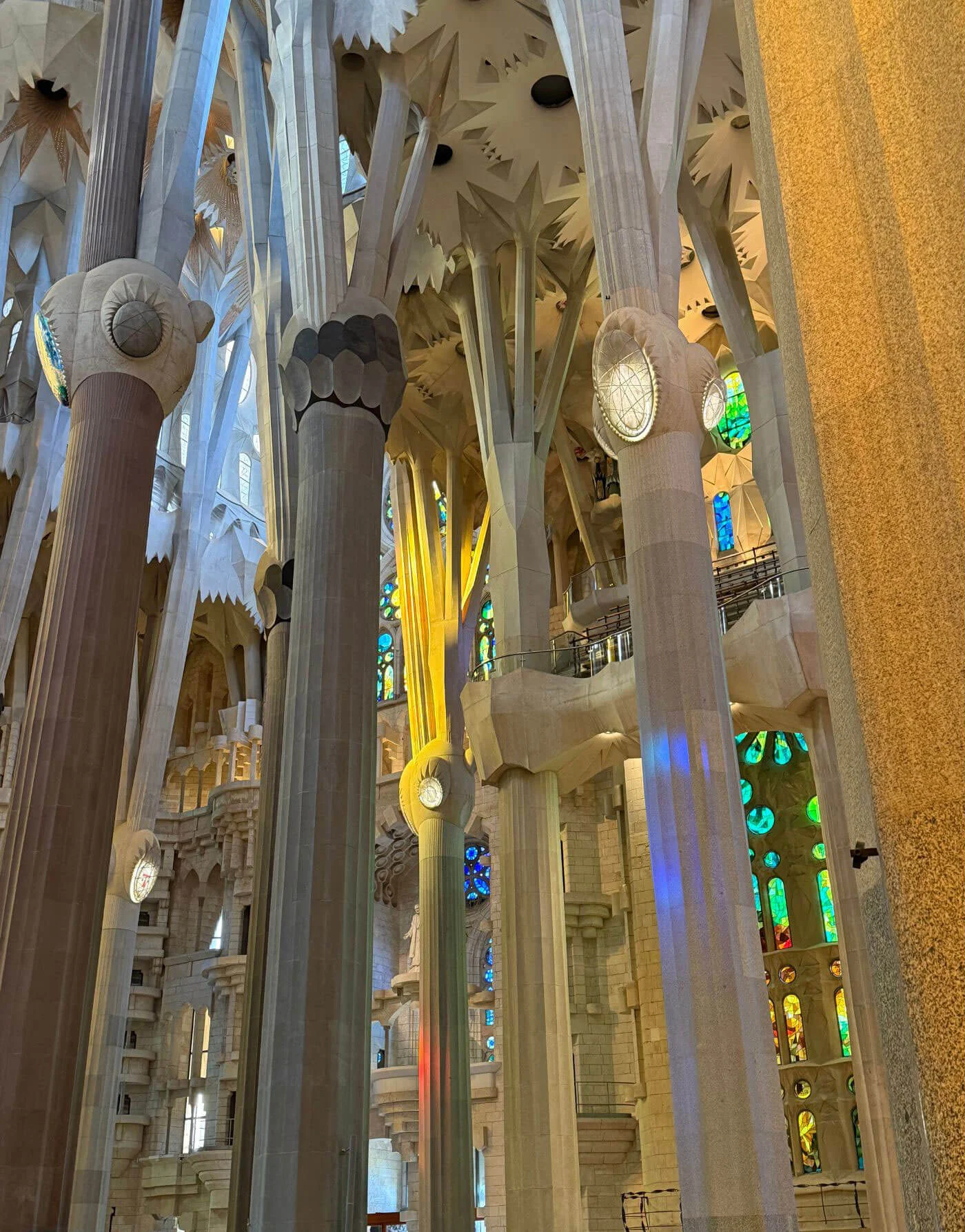 Tall interior columns beside warm stained-glass light
