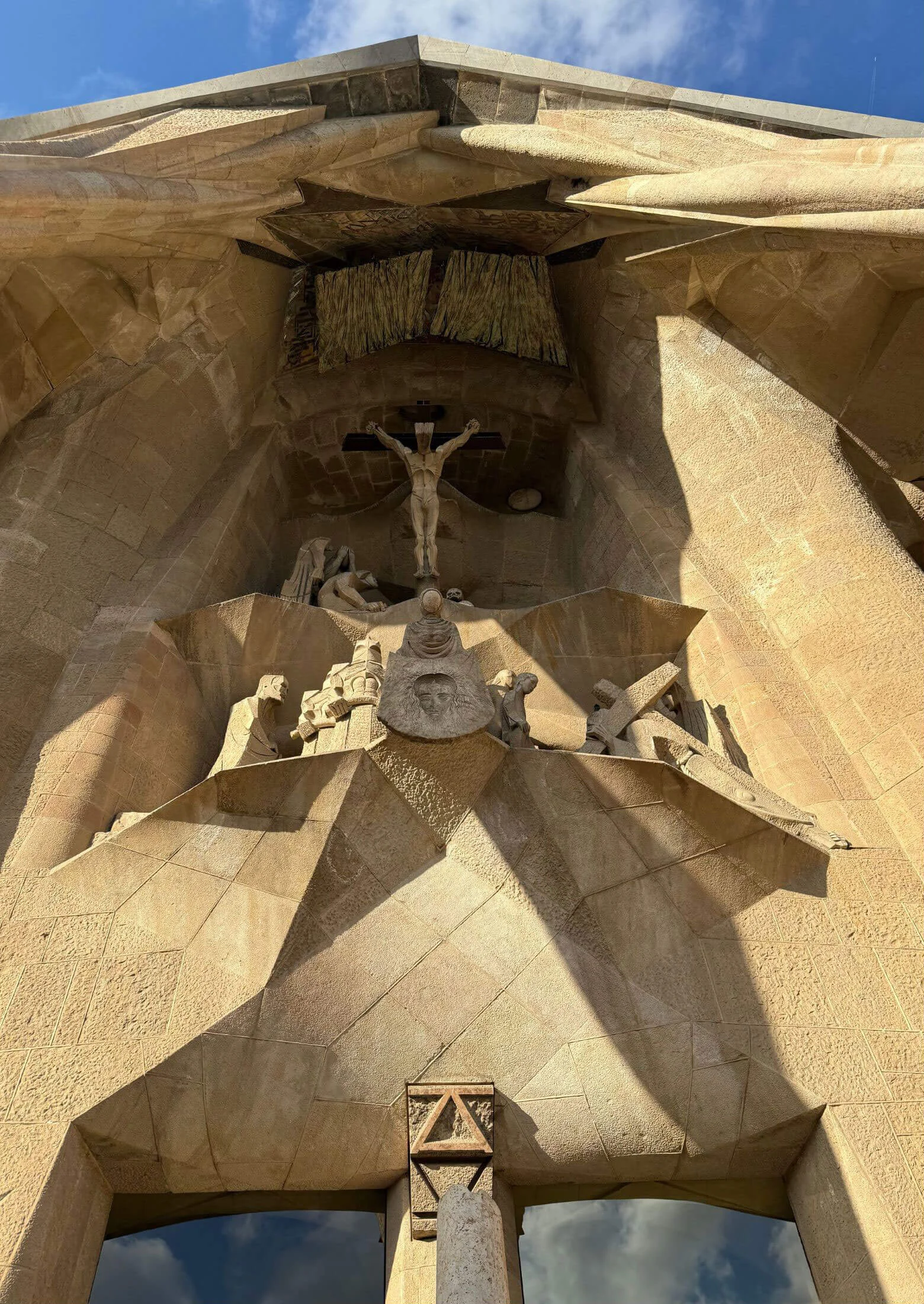 Angular stone figures beneath a projecting entrance canopy