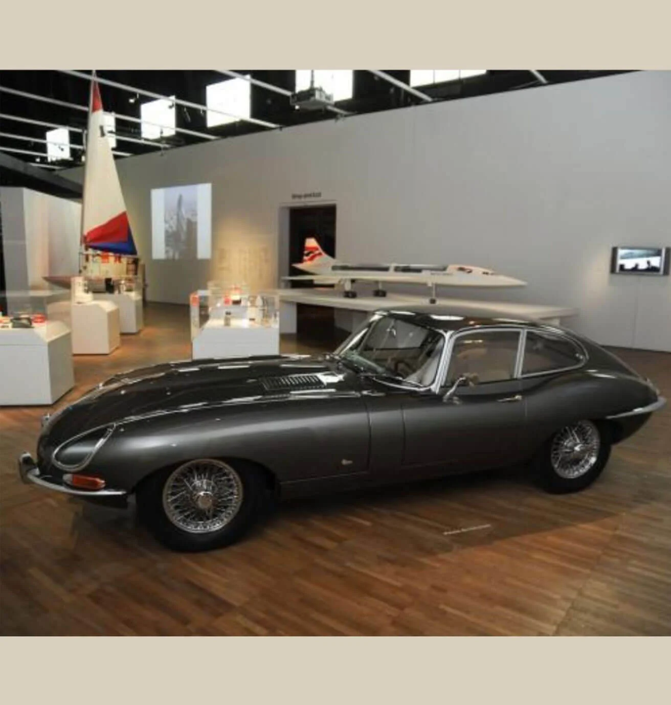 Dark E-type coupe displayed in a museum