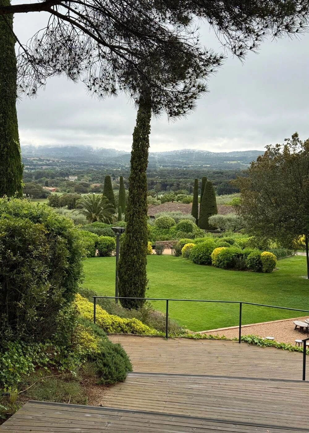 Garden steps descending toward cypresses and distant hills