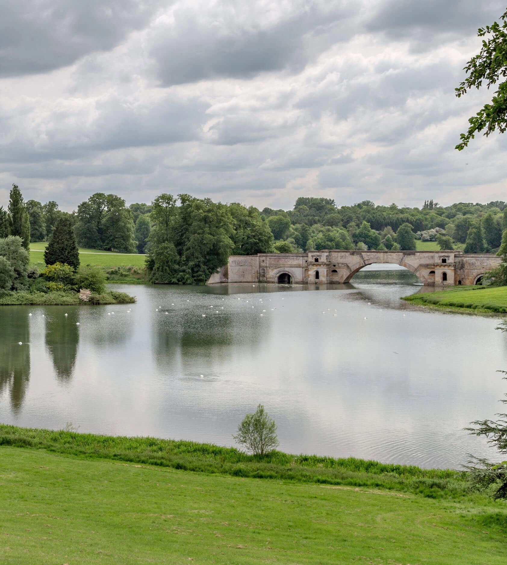 Stone bridge spanning the landscaped lake