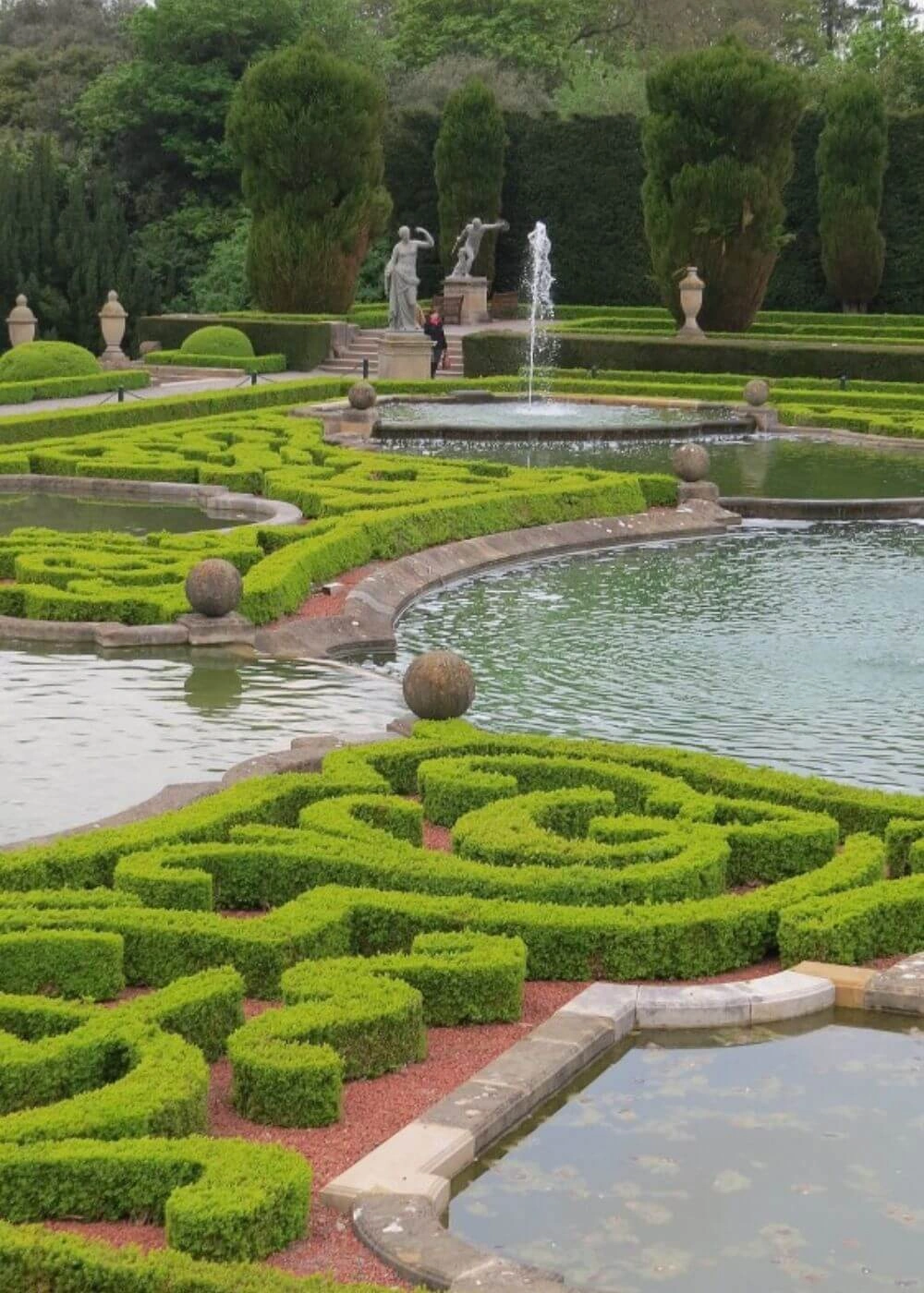 Curved ornamental hedges beside a reflecting pool