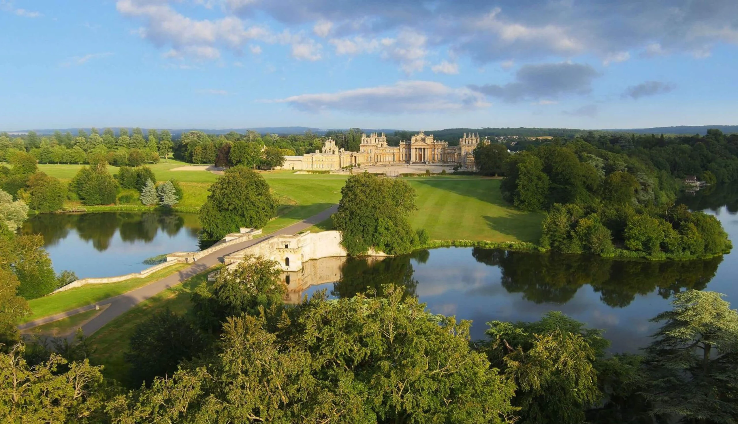 Palace and bridge surrounded by green parkland