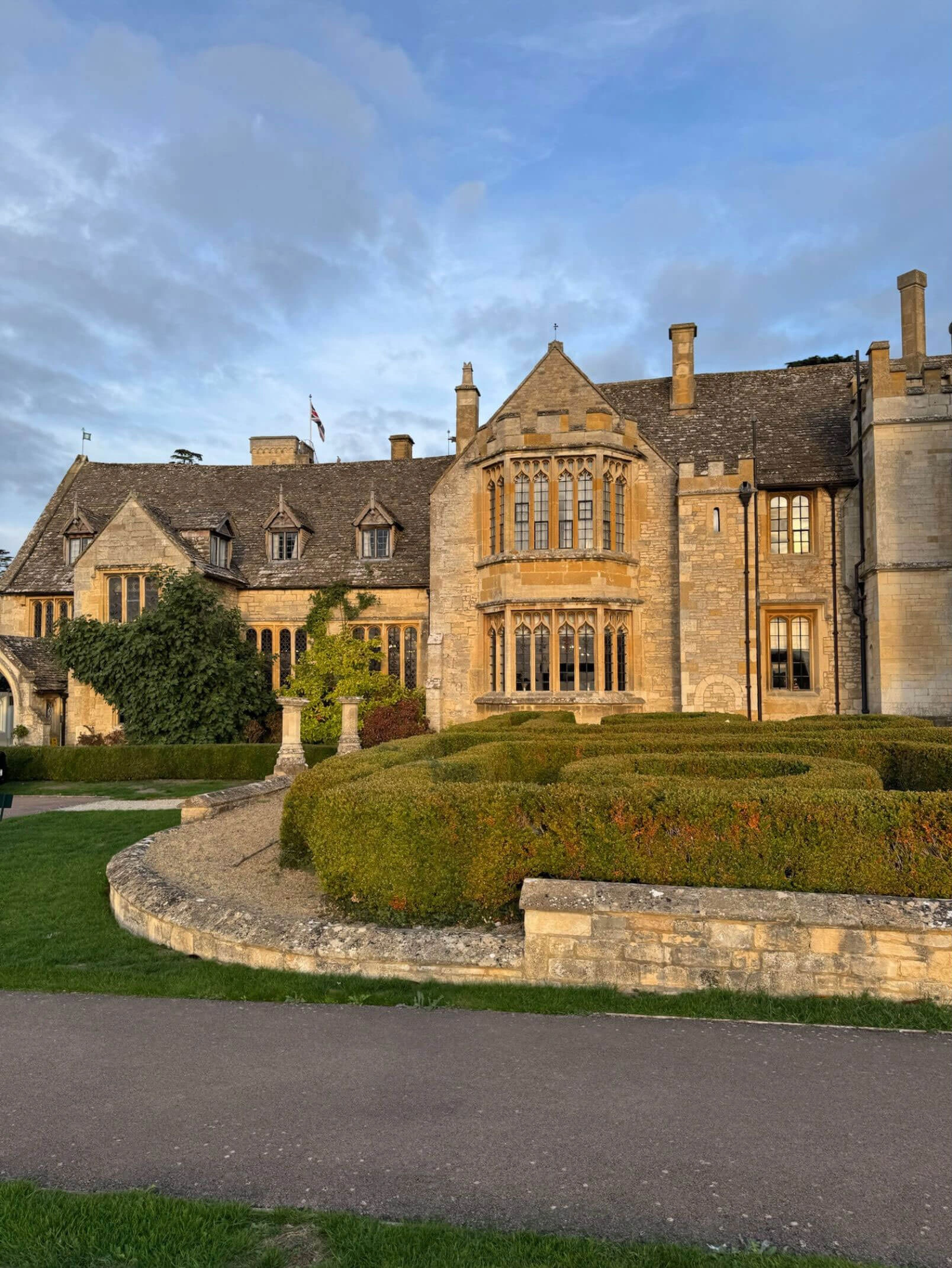 Ellenborough Park stone facade and formal garden in golden light