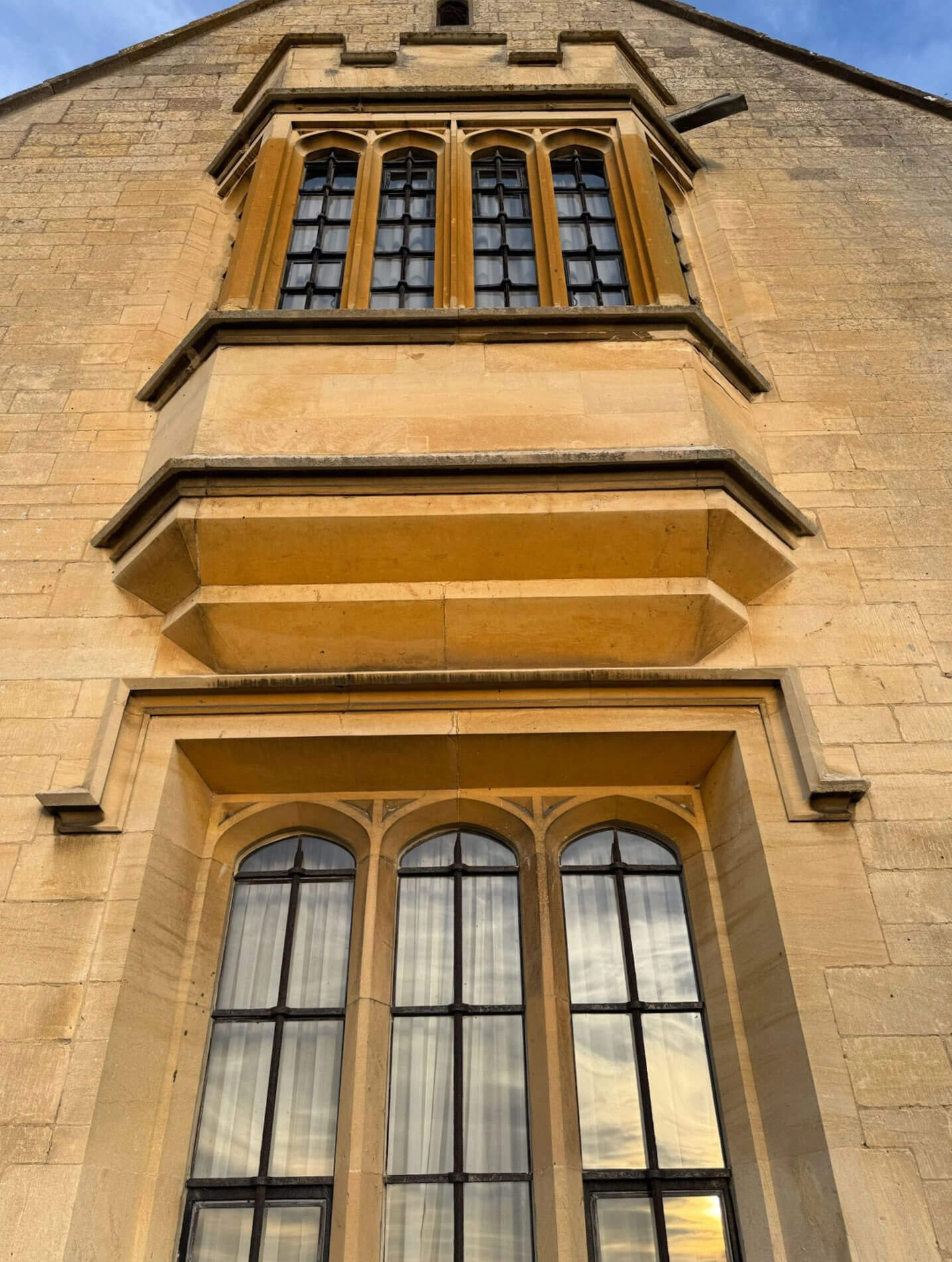 Projecting upper window above a tall arched window