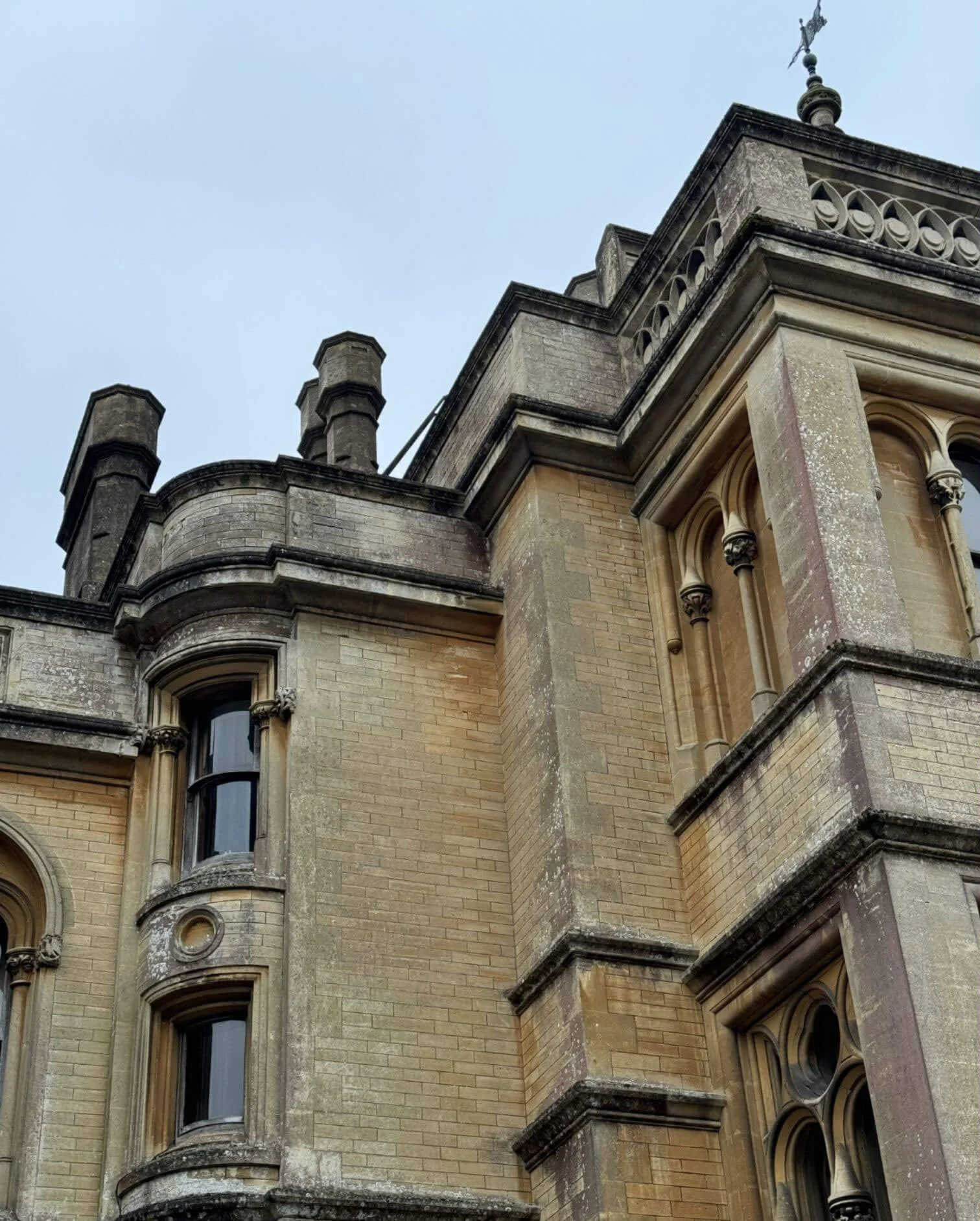 Carved stone manor facade with curved bays and rooftop finials