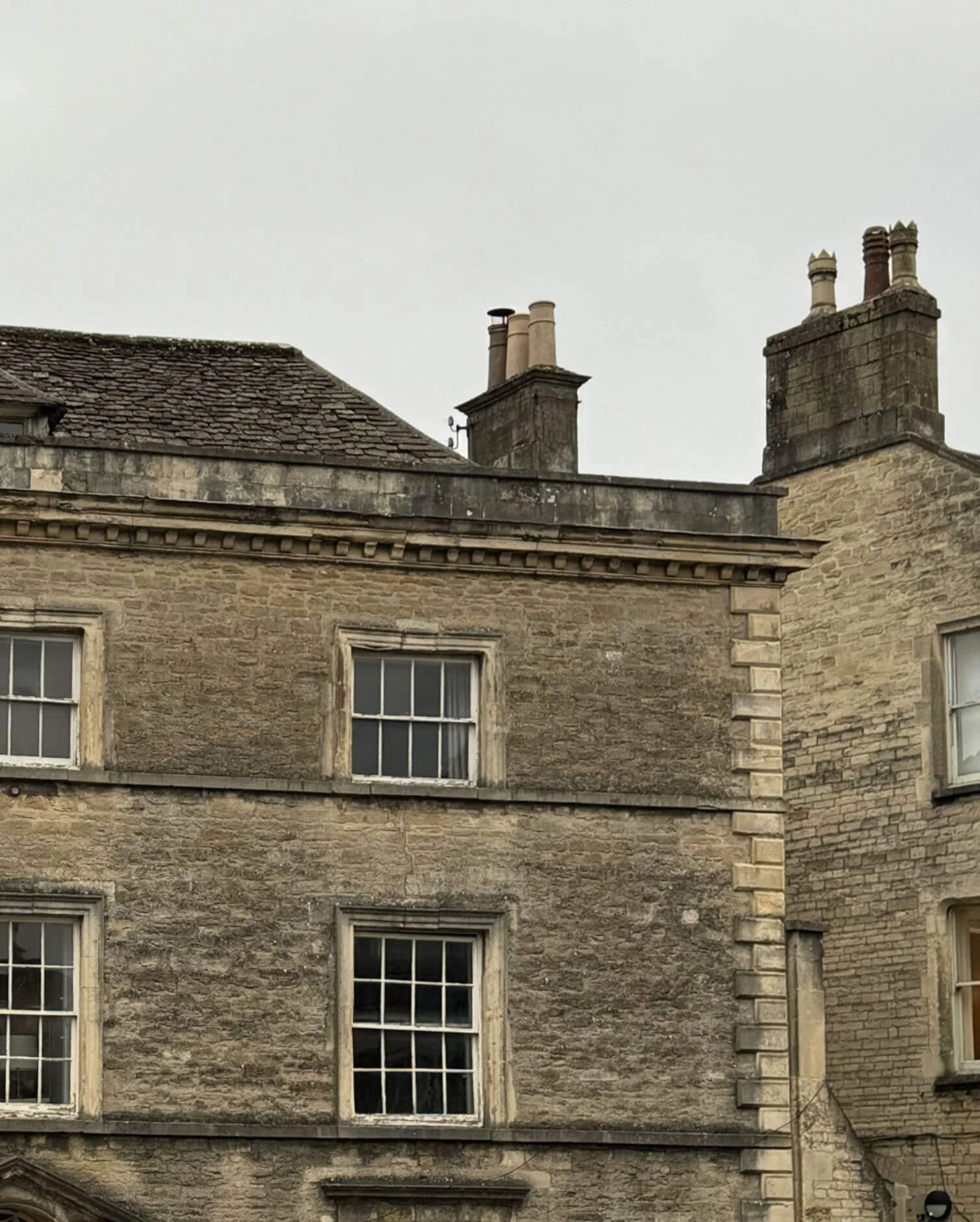 Weathered stone facade with sash windows and chimneys