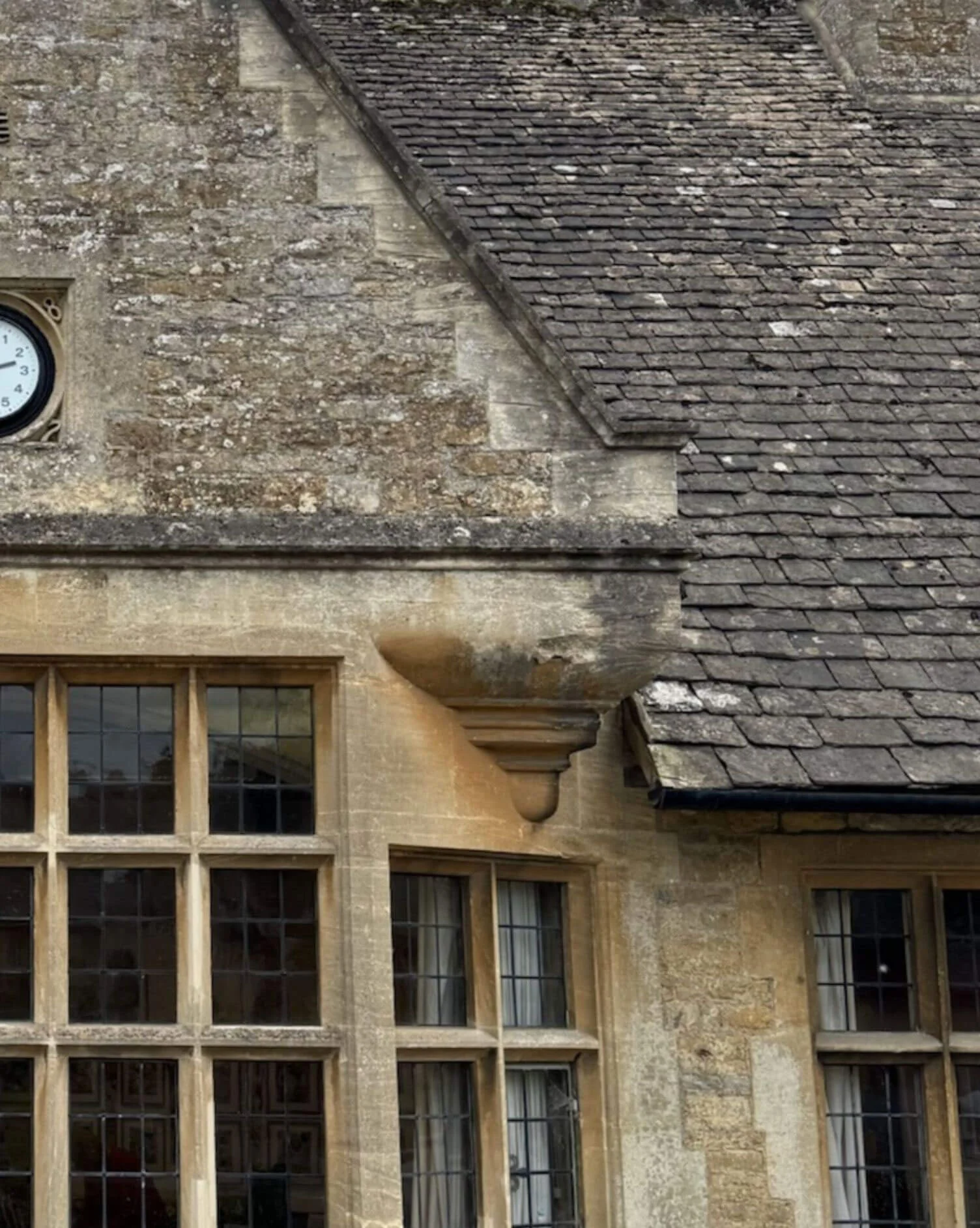 Steep stone gable above mullioned windows