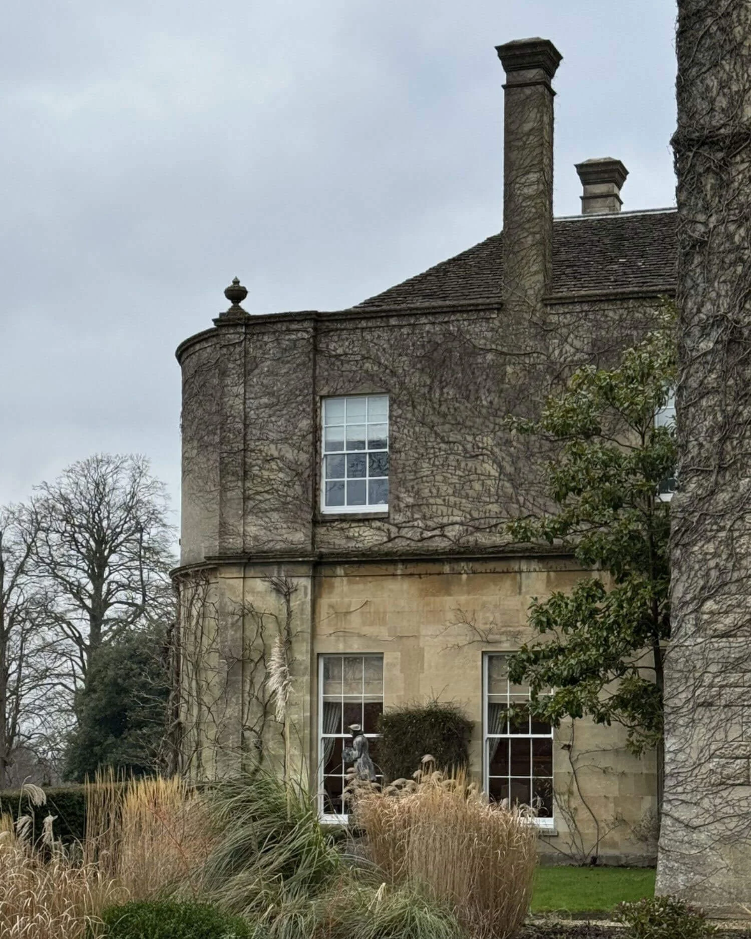 Stone house with a tall chimney and garden planting