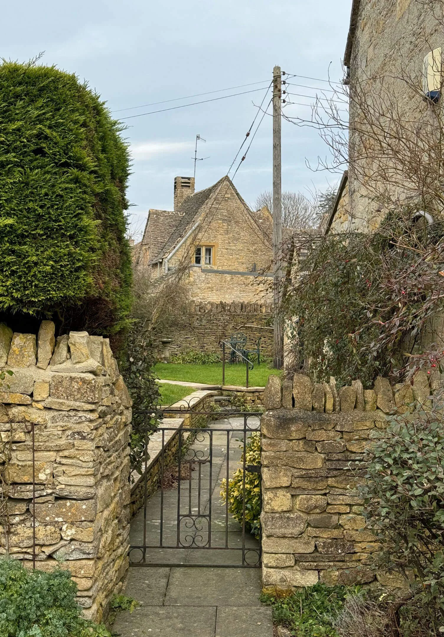 Garden gate framing a stone house