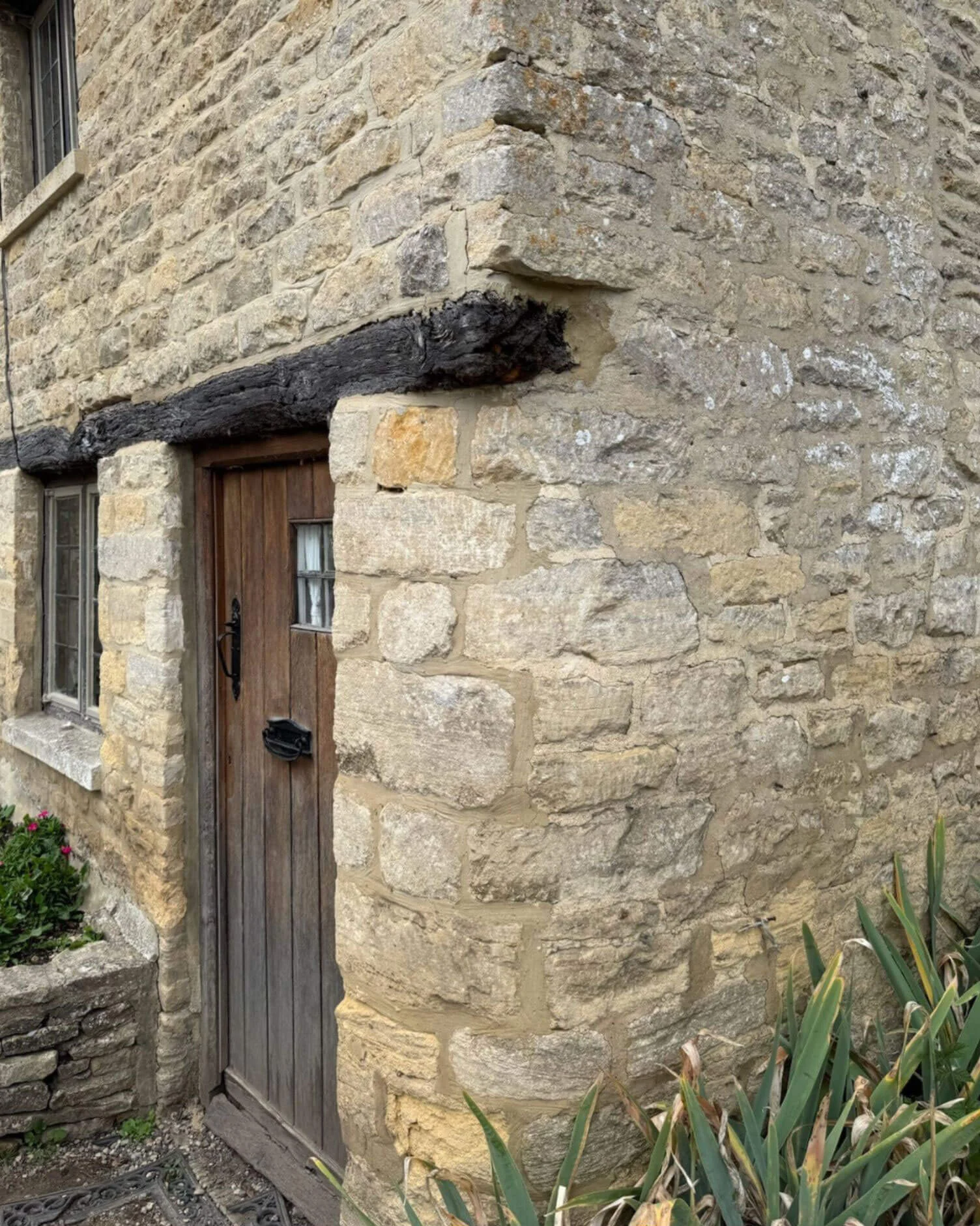 Timber door beneath a heavy lintel in a stone wall
