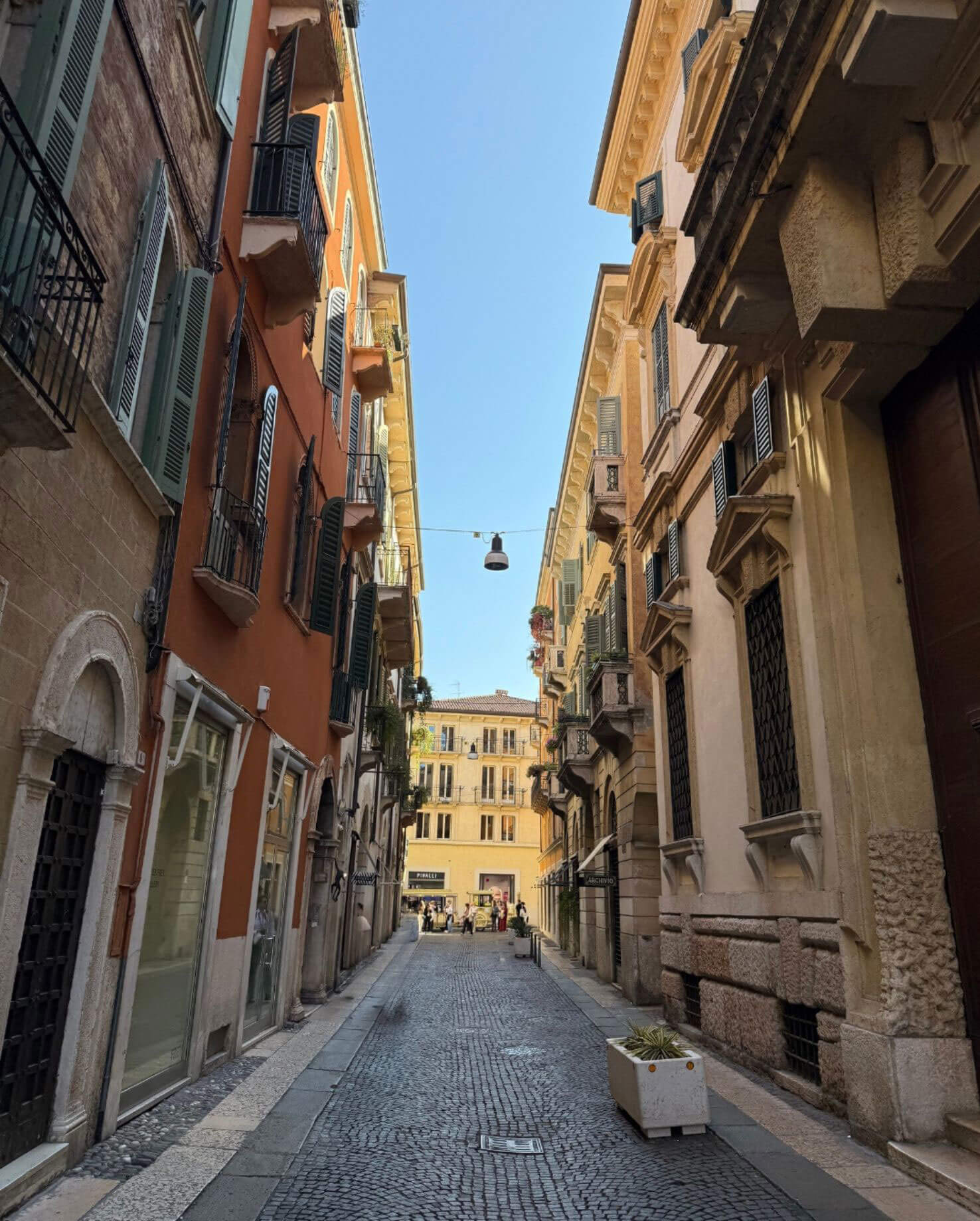 Cobbled Verona street between tall colourful buildings