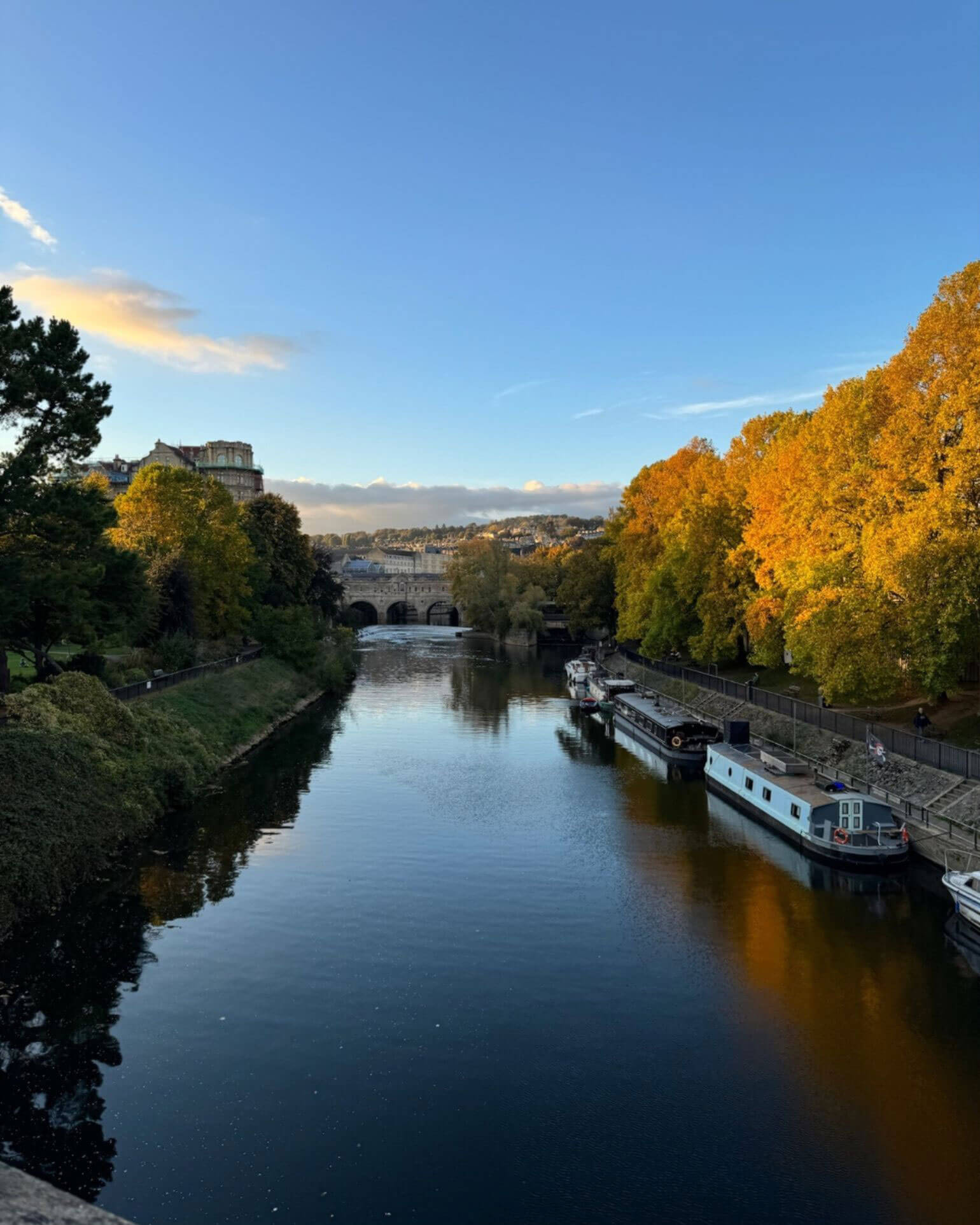 River with moored boats and golden autumn trees