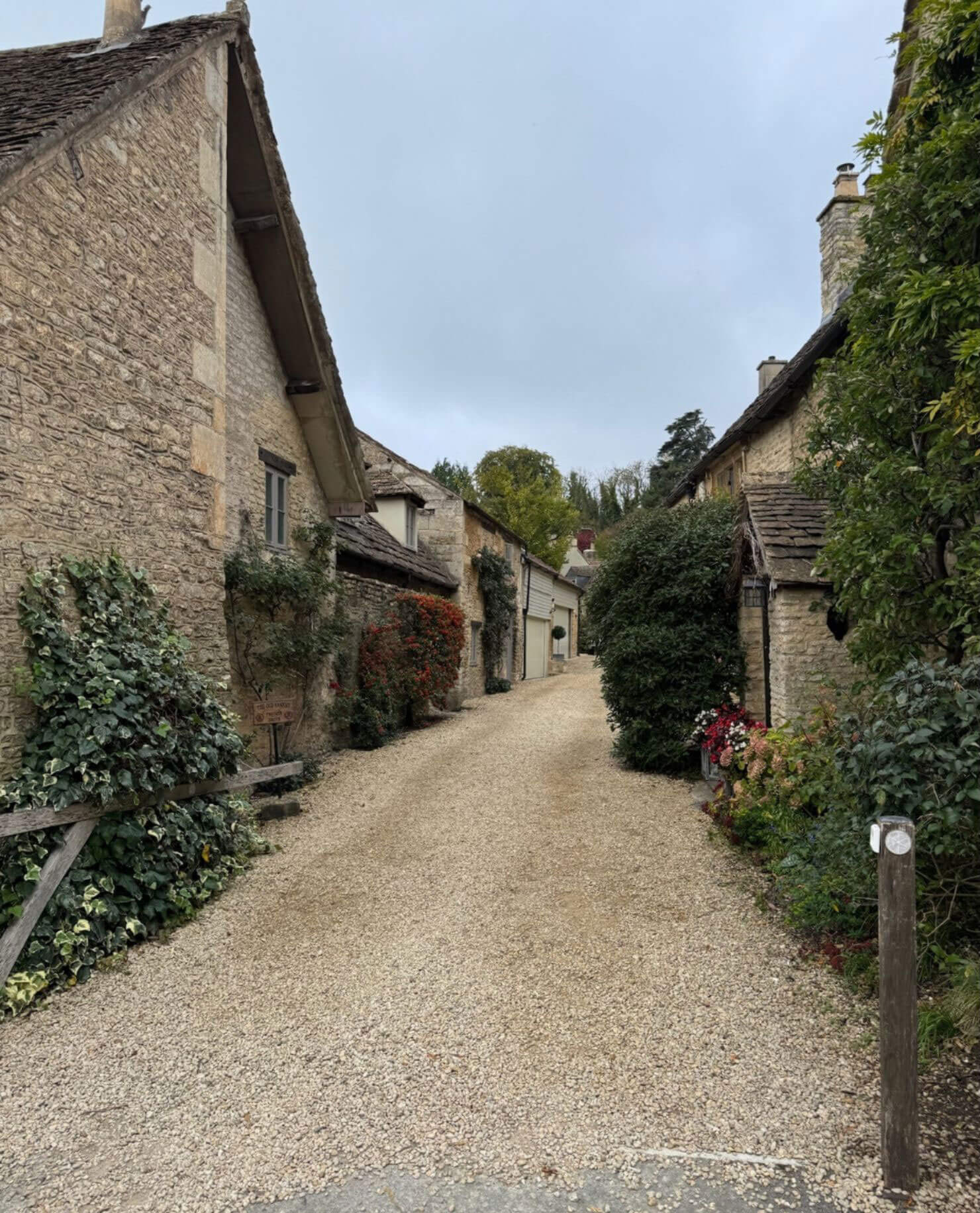 Gravel lane between stone houses and garden planting
