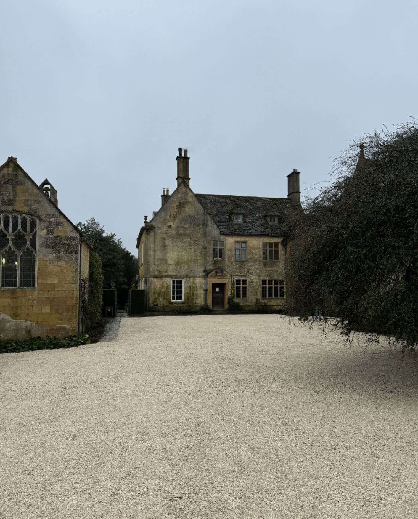 Gravel forecourt enclosed by stone country houses