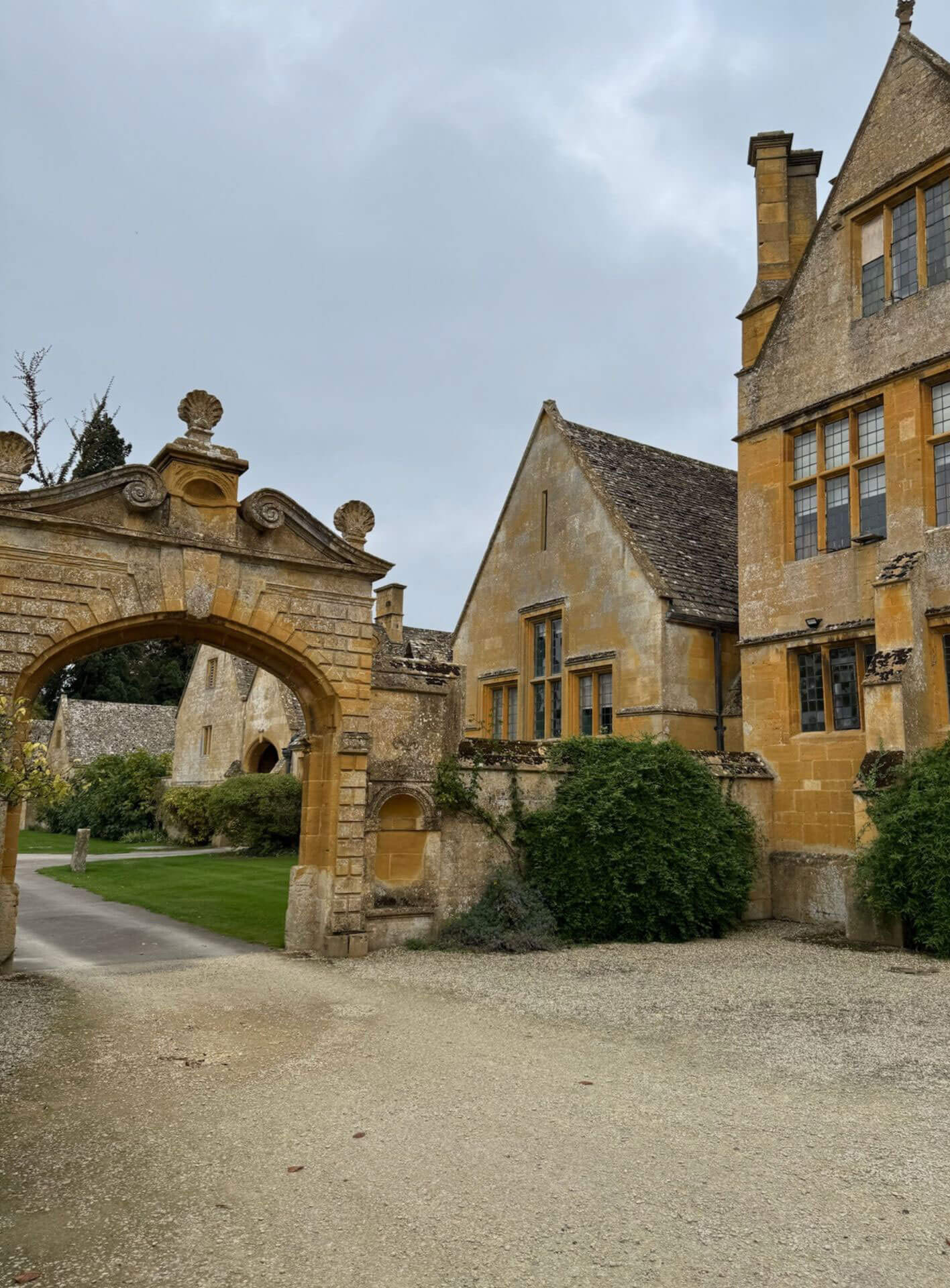 Ornate stone gateway beside the manor facade