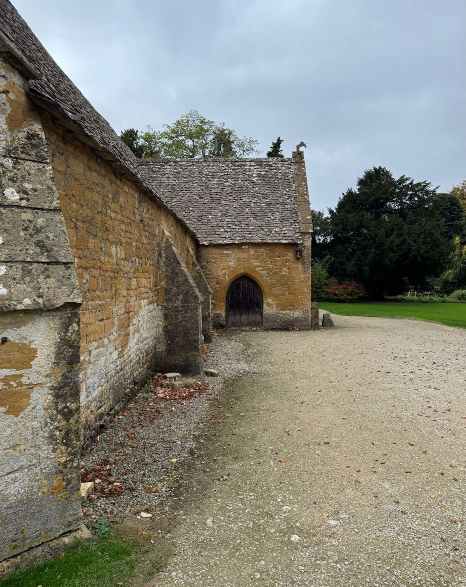 Stone courtyard buildings beside a gravel path