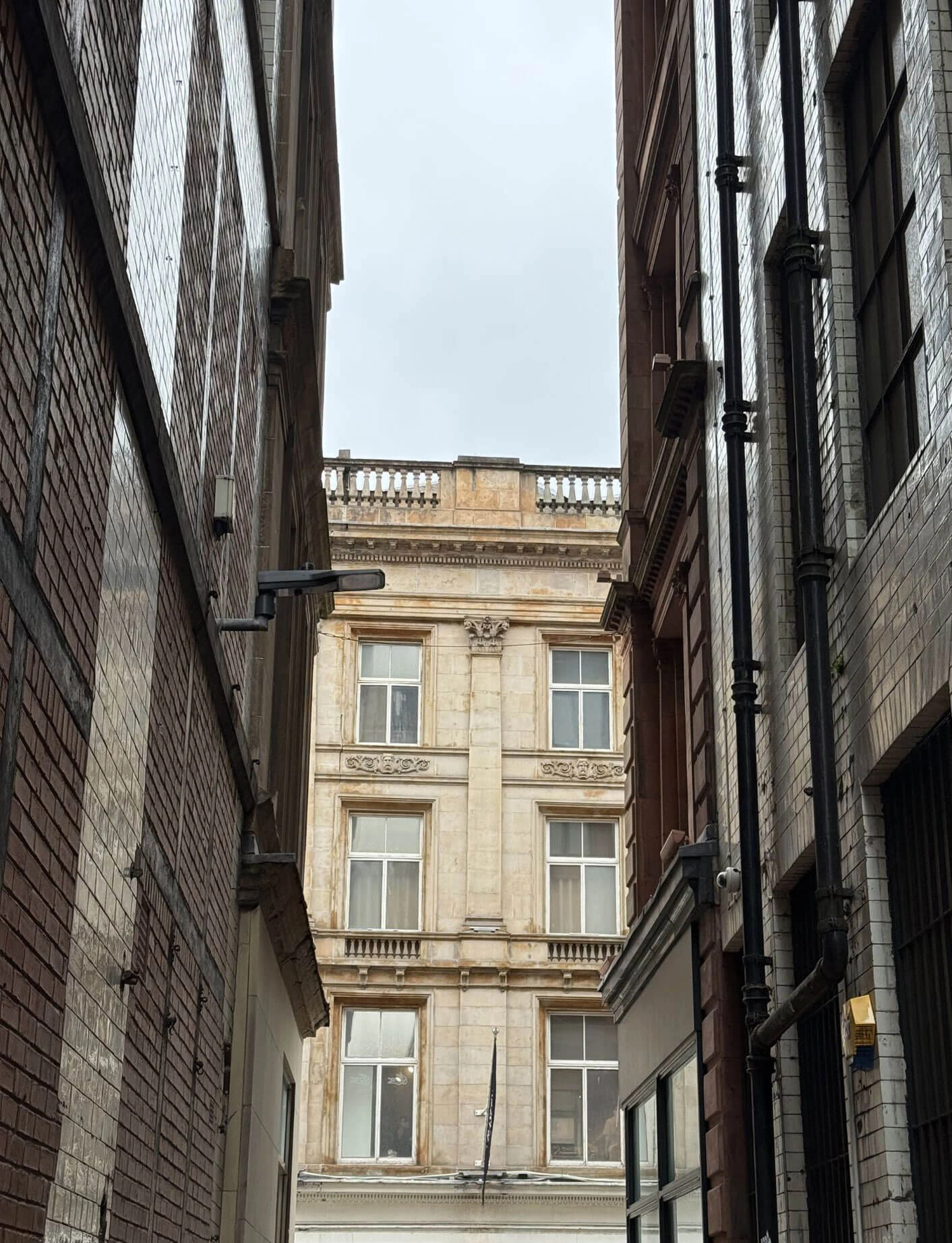 Narrow passage framing a classical stone facade