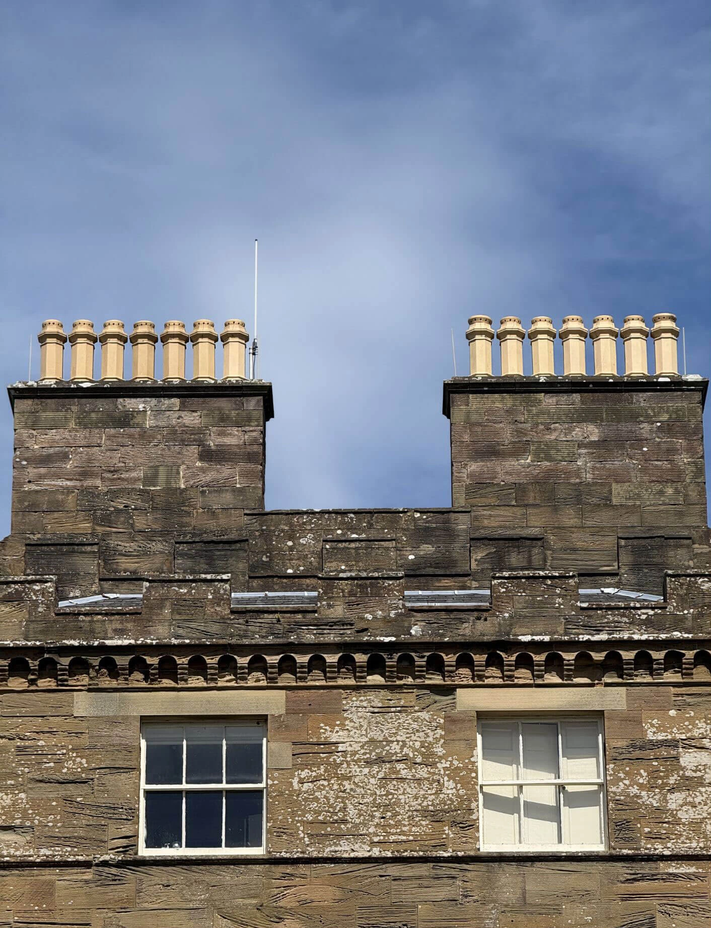 Twin stone chimney stacks topped with clay pots