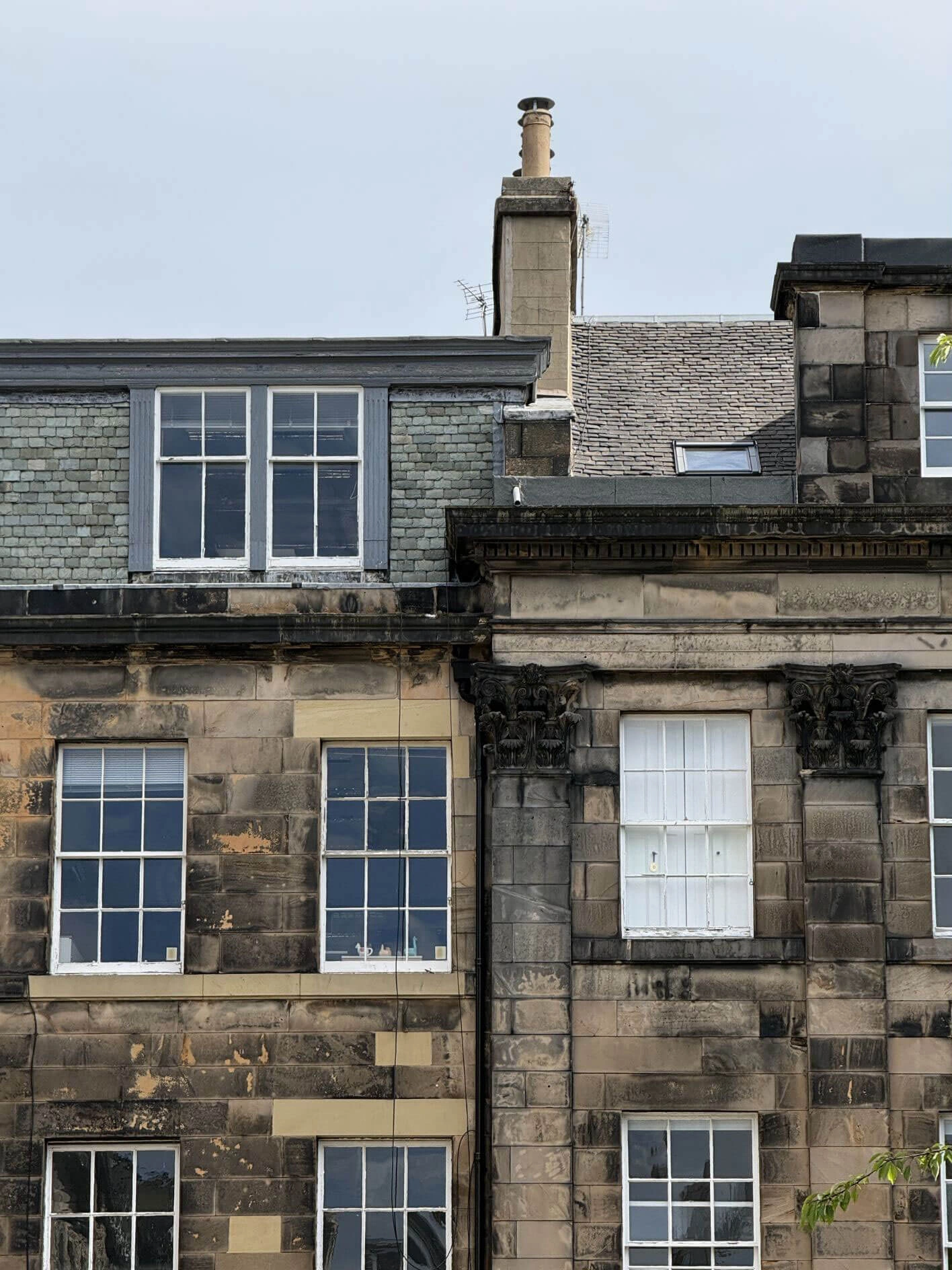 Stone facade with sash windows and a dormer