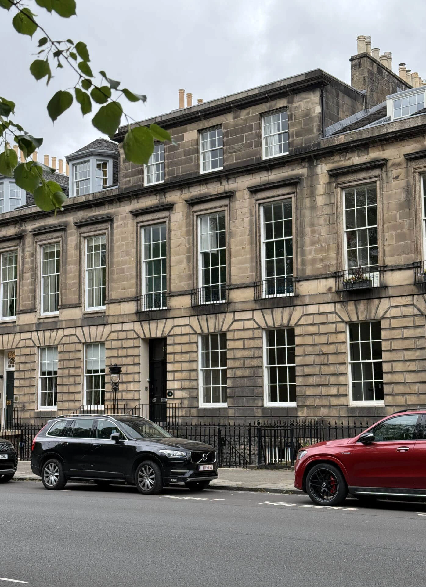 Stone terrace with sash windows beneath leafy branches